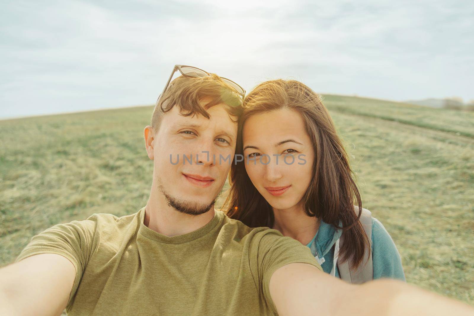 Loving couple doing selfie in the mountains by alexAleksei