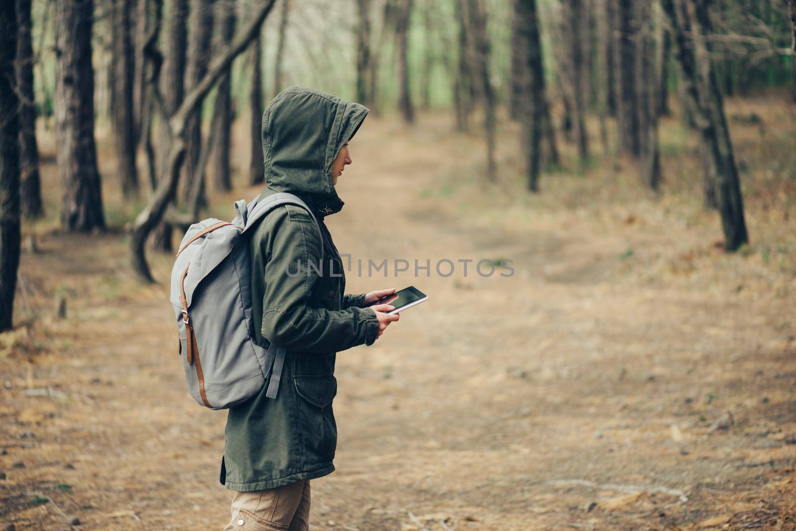 Hiker young woman working on digital tablet PC in the forest