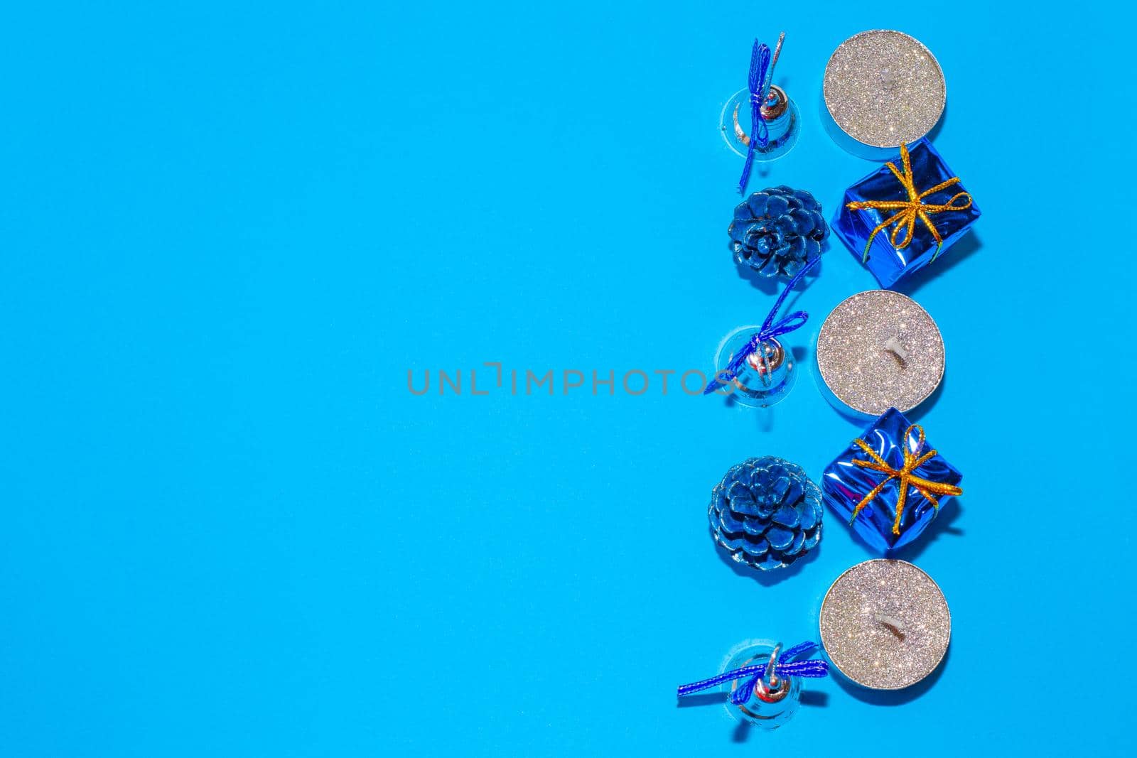 candles and christmas decorations on blue background, christmas festive background, flat layout, top view.