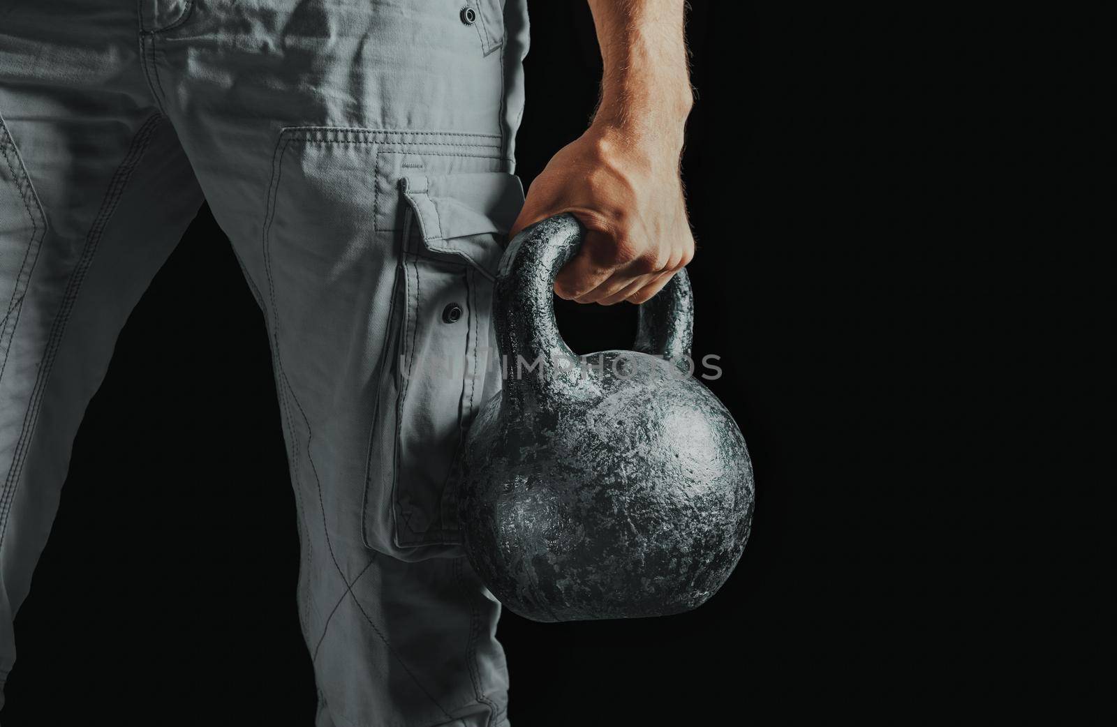 Close-up image of male hand with kettlebell. Copy-space in right part of the image