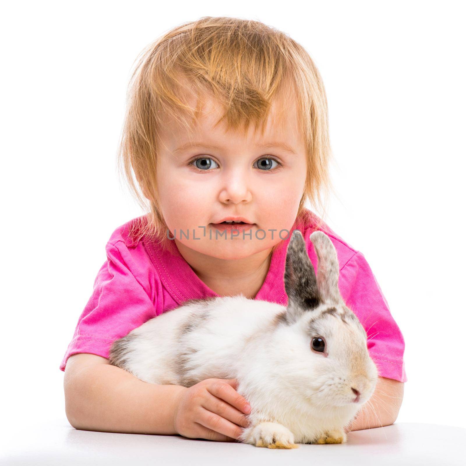 baby girl in a pink T-shirt with her small white rabbit close-up