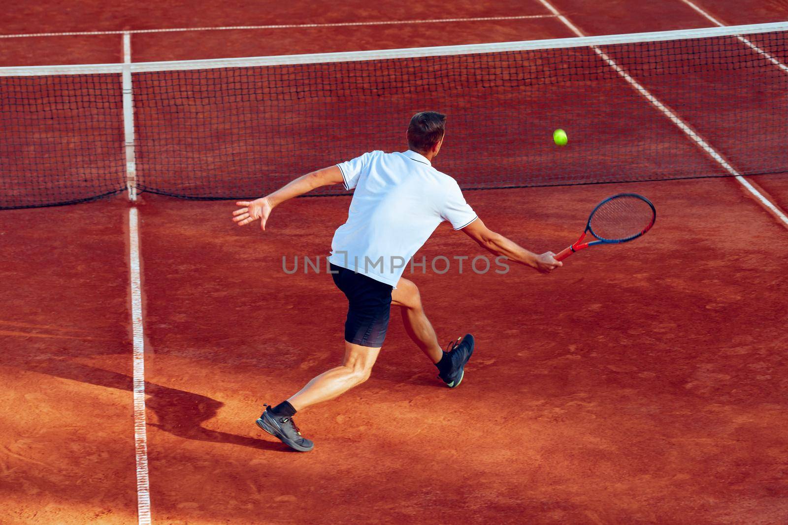 Back view photo of a man playing tennis on tennis court