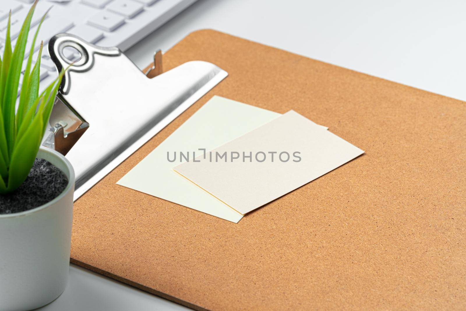 Blank business cards with supplies and keyboard on office table. Close up.