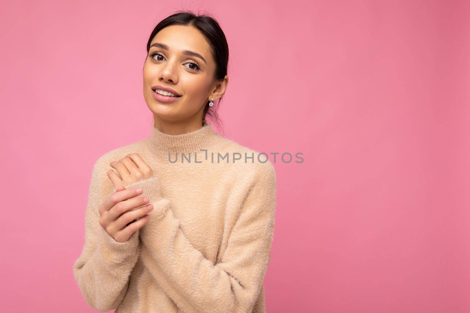Beautiful cute nice adorable tender young brunette woman in casual beige jersey isolated on pink background with free space and enjoying by TRMK