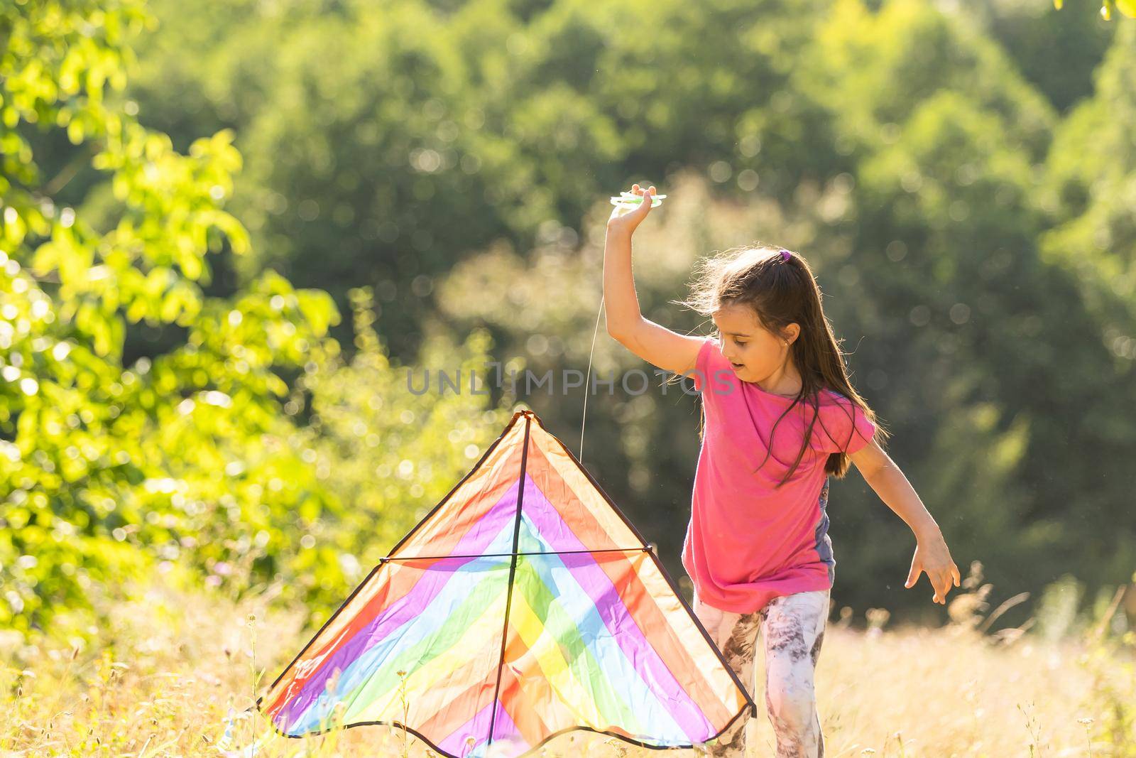 little girl running outdoor with a kite