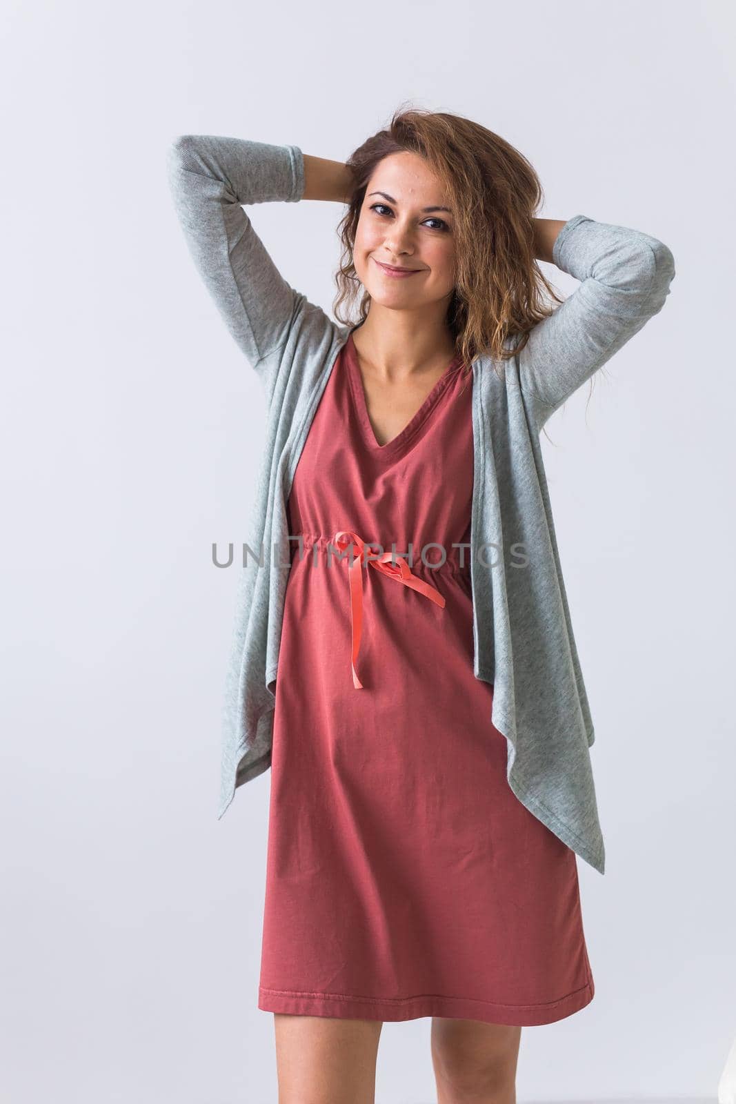 Beautiful young woman smiling against white background. Comfortable homewear, home relaxation and female fashion.