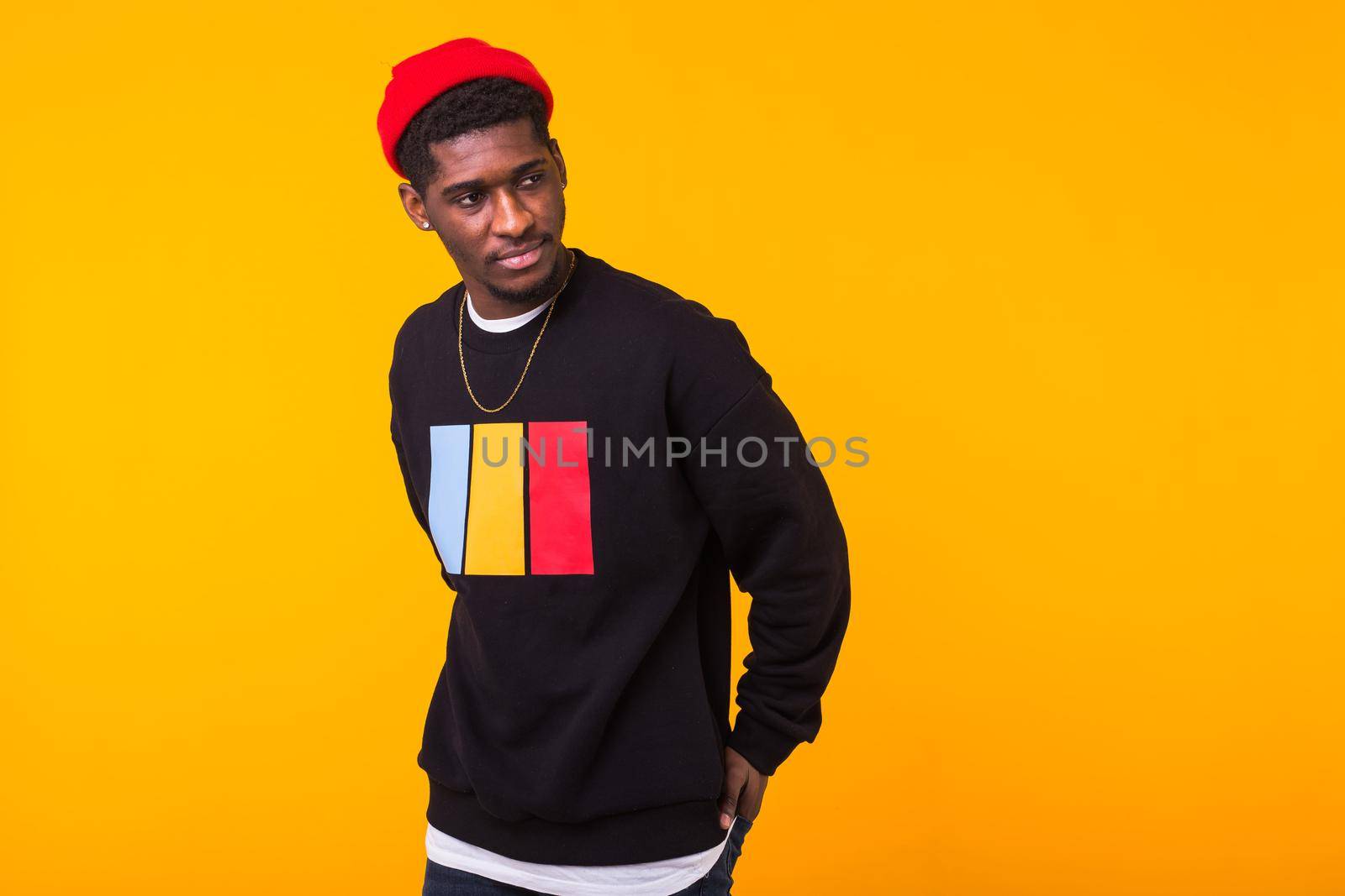 Studio shot of young handsome African man wearing hoodie against white background.