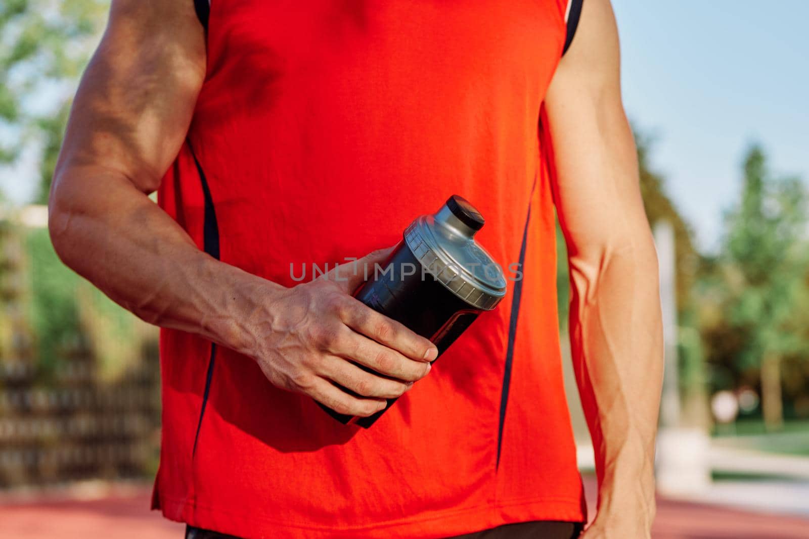 sporty man resting in the park on a bench having a snack. High quality photo