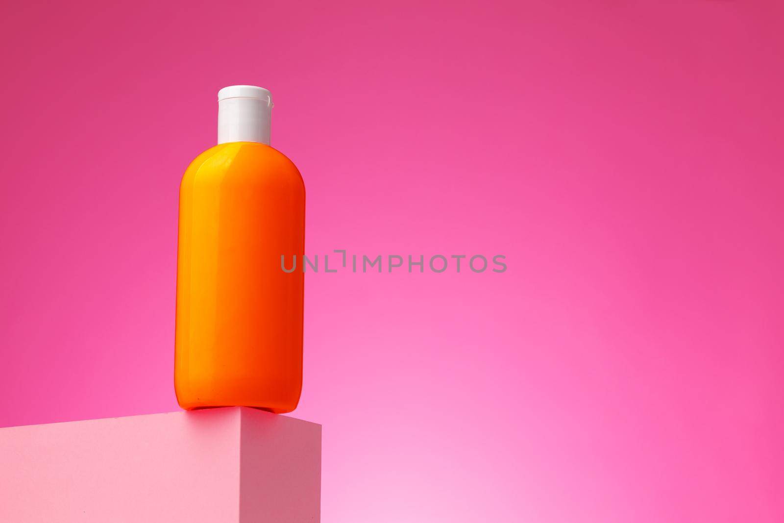 Skincare beauty products container against pink background, copy space