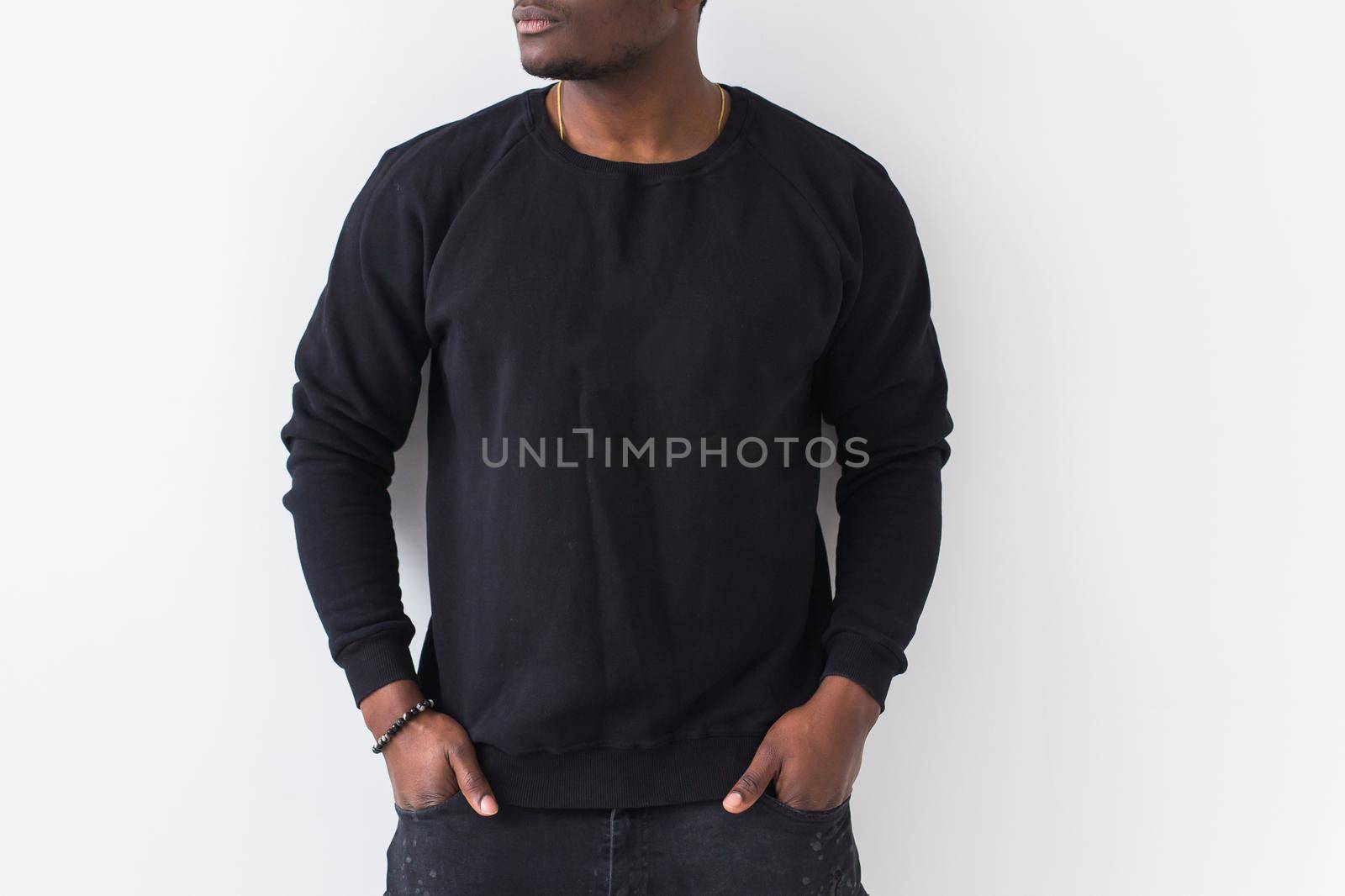 Handsome African American man posing in black hoodie on a white background. Youth street fashion photo with afro hairstyle