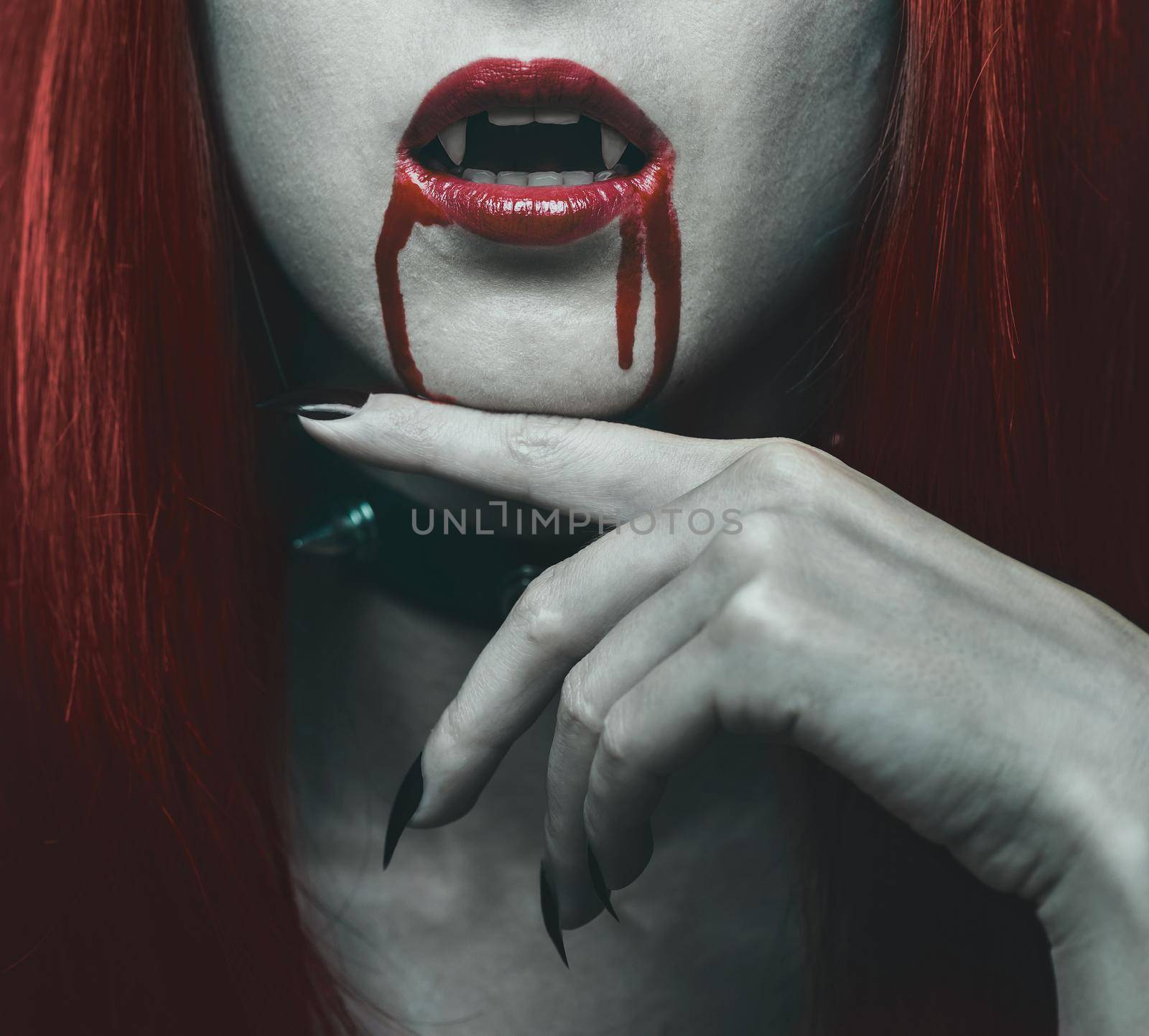 Beautiful vampire woman, close-up red lips in blood. Halloween or horror theme