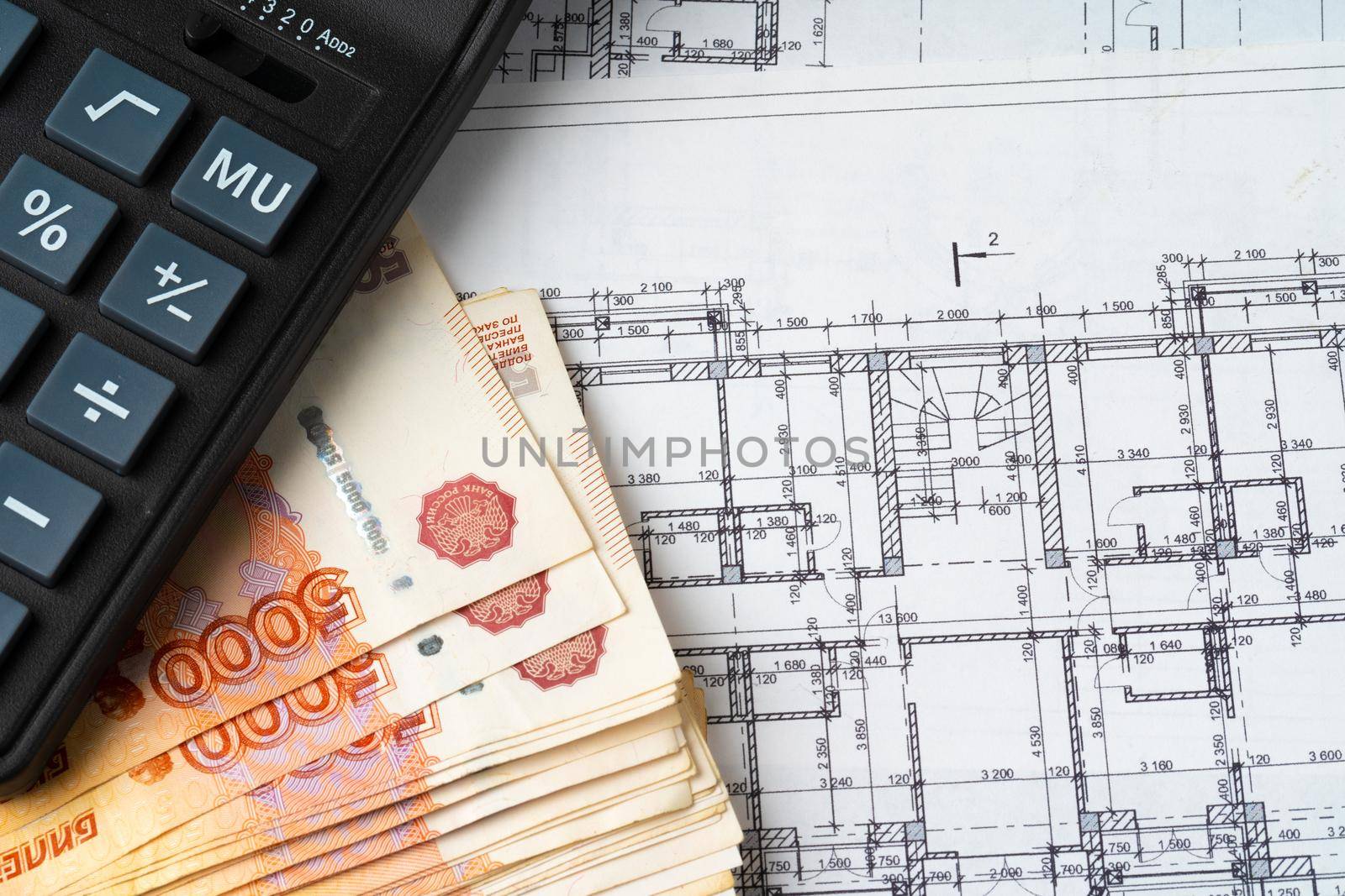 Russian roubles stack on blueprints wth calculator. Renovation, building expenses concept. High quality photo