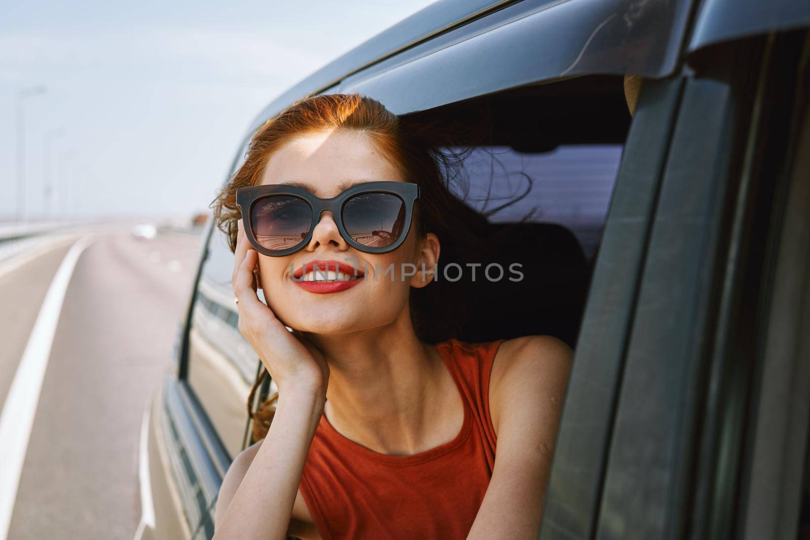 pretty woman in sunglasses rides in a travel car. High quality photo