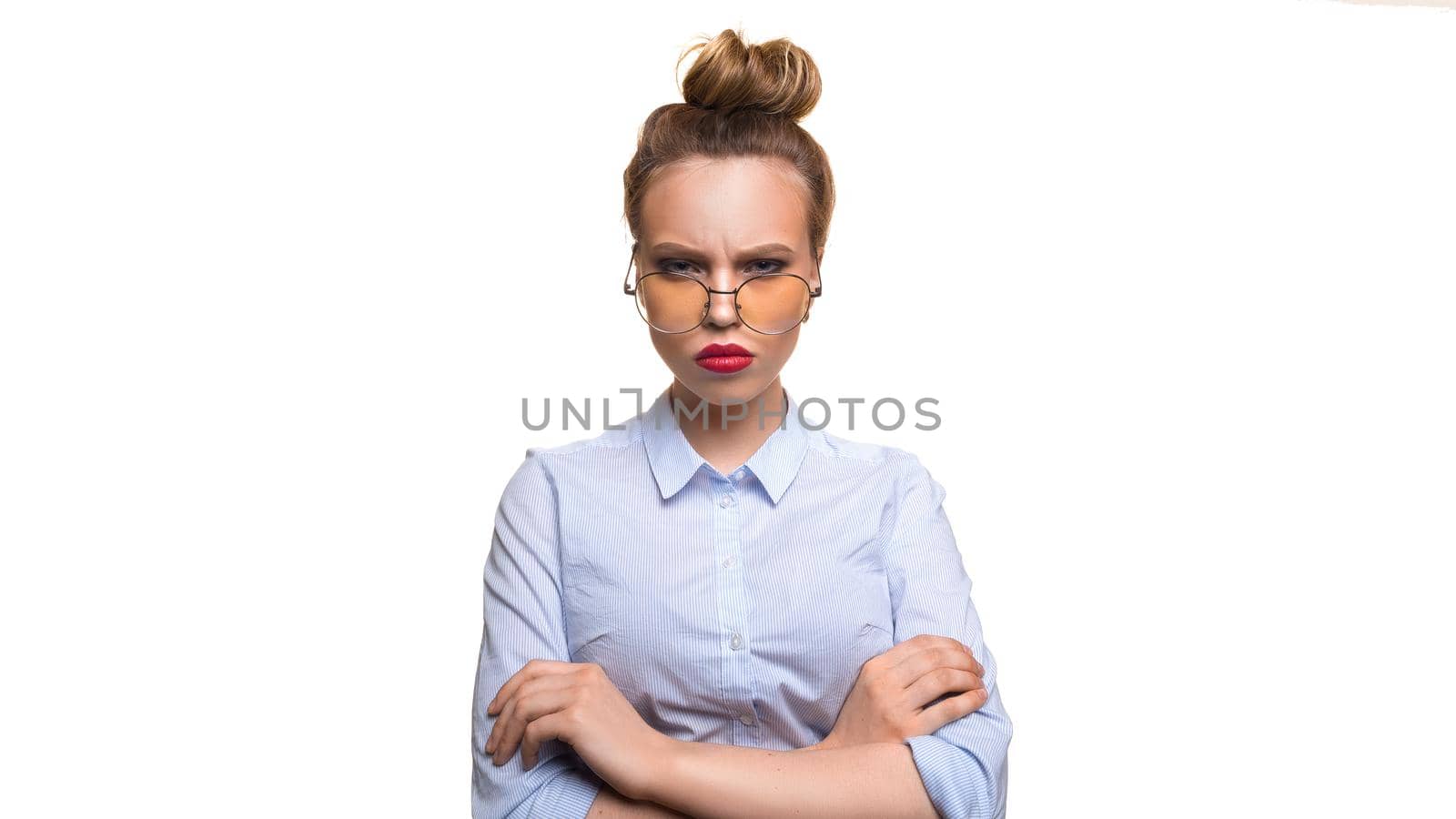 Dissatisfied girl with glasses looking at the camera. Isolated on a white background.