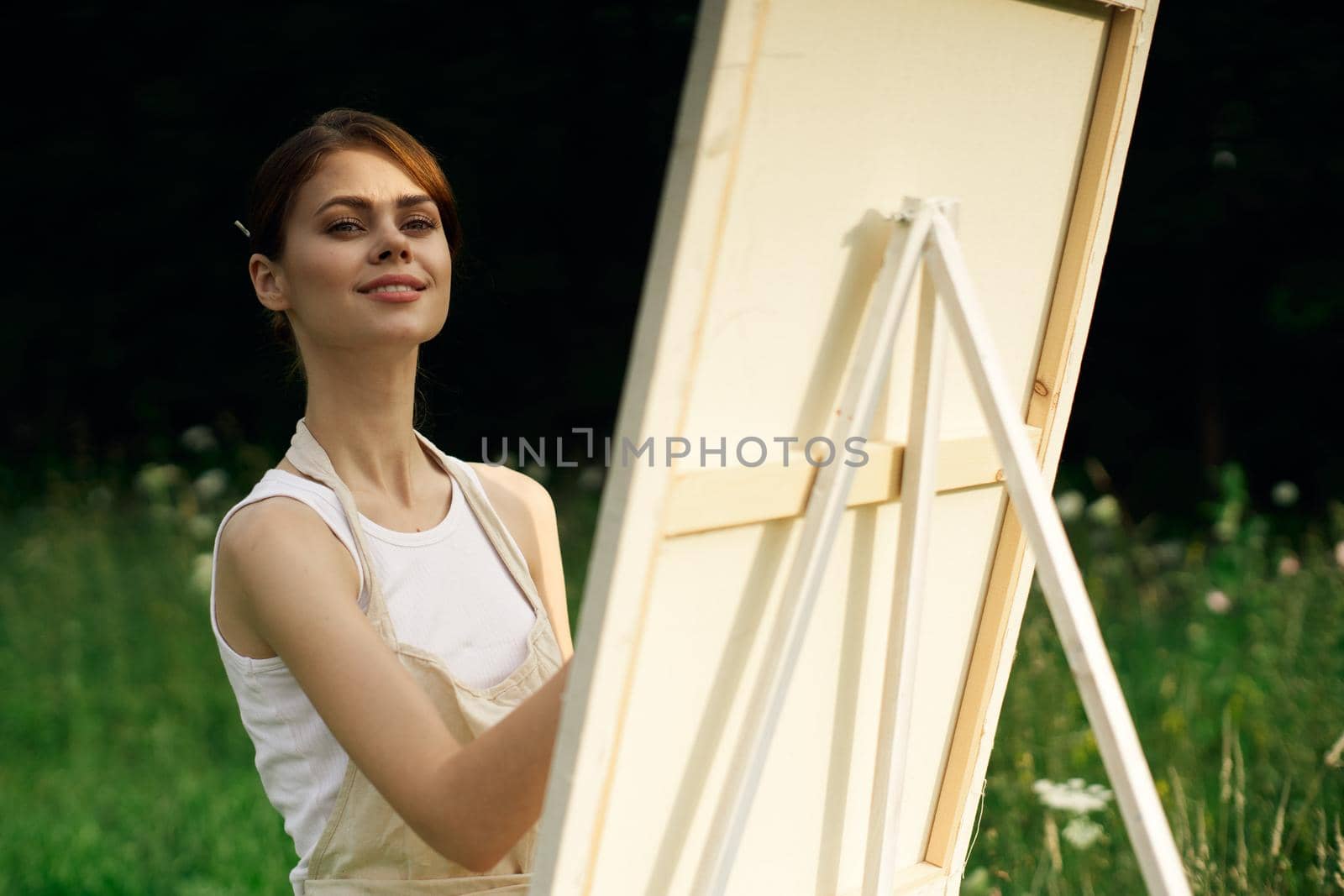 woman artist paints a picture near easel outdoors landscape creative. High quality photo