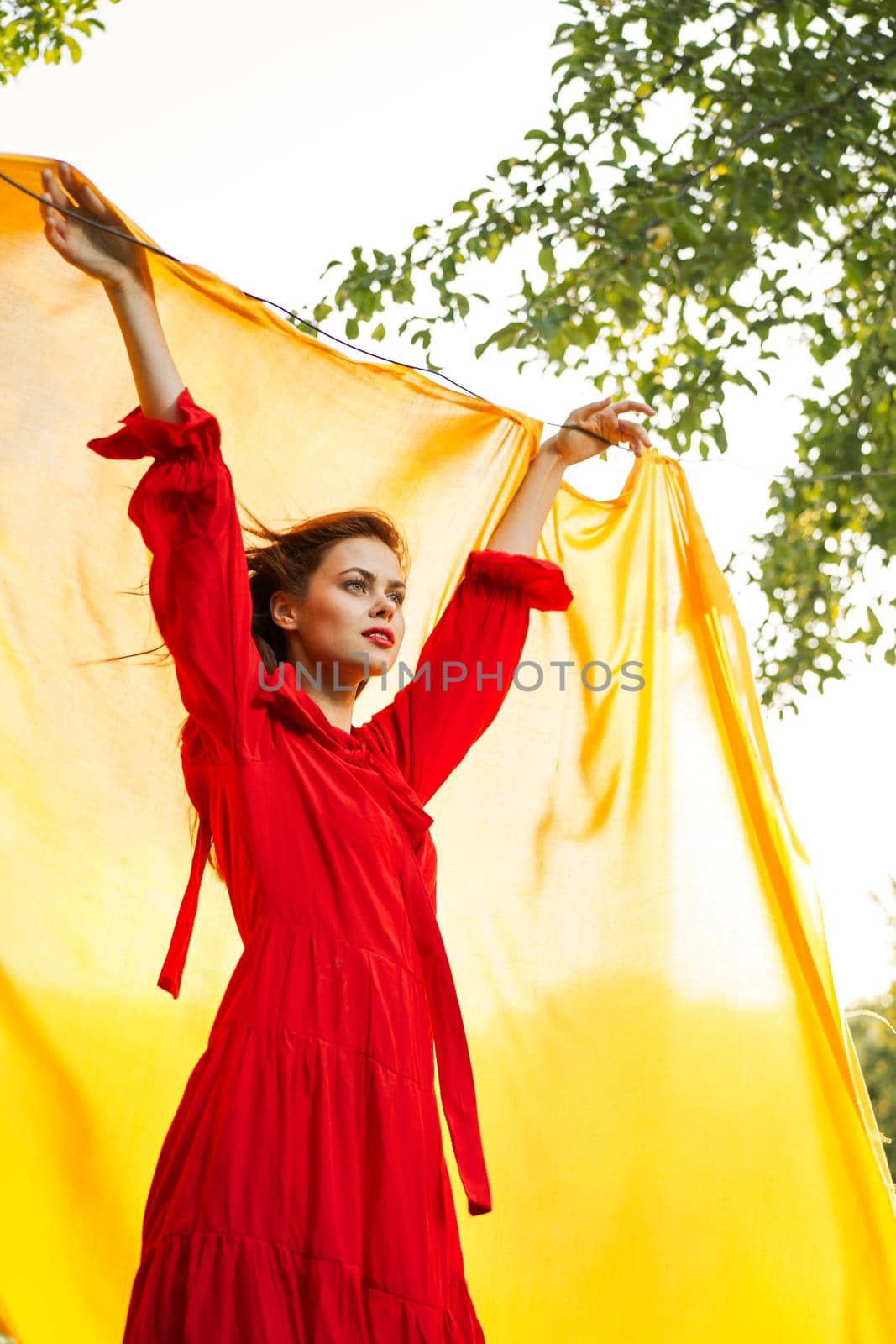 festively outdoors yellow cloth on the background of posing red dress by Vichizh