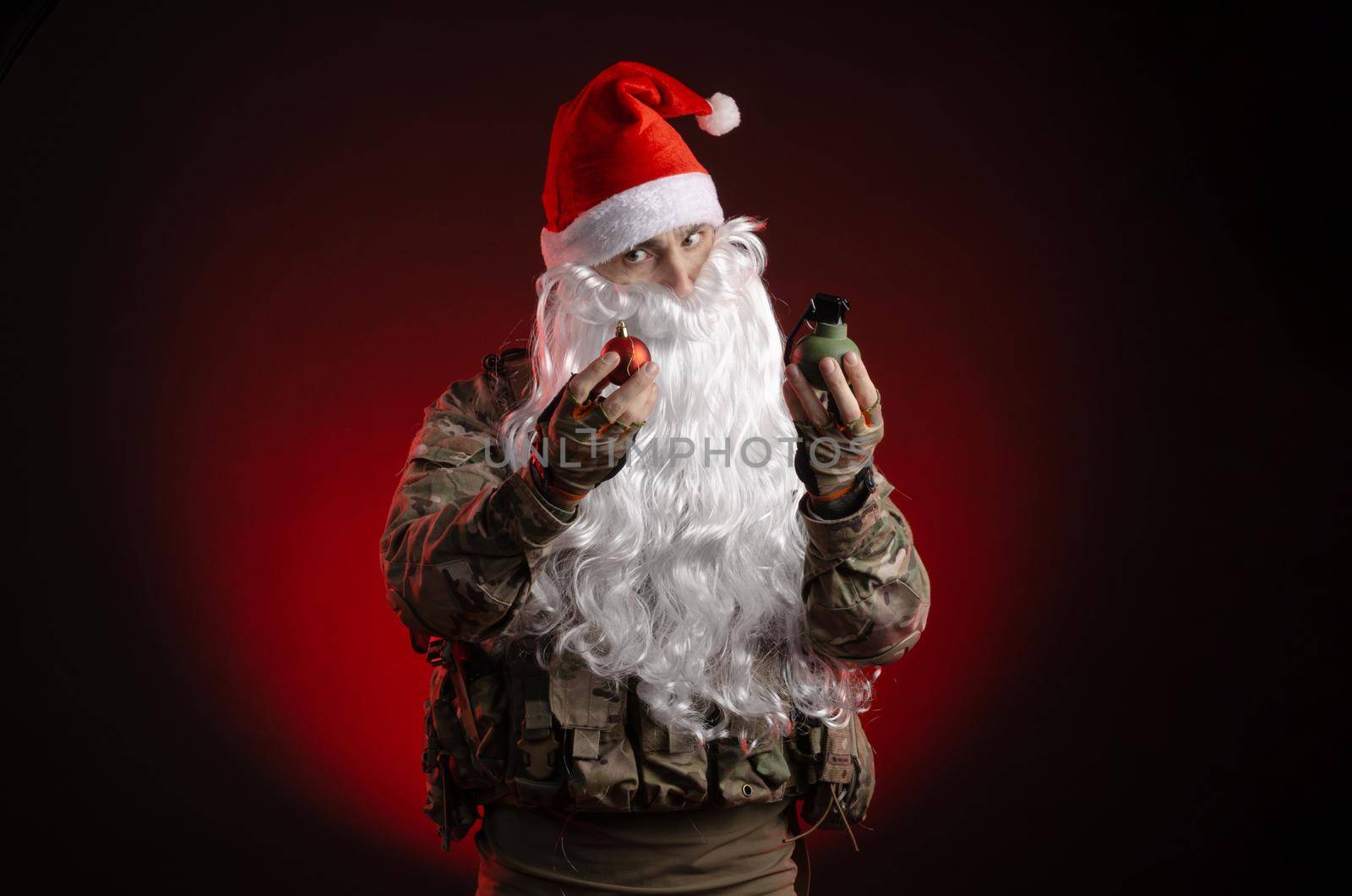 the man in a military uniform with a gun and a Santa Claus hat