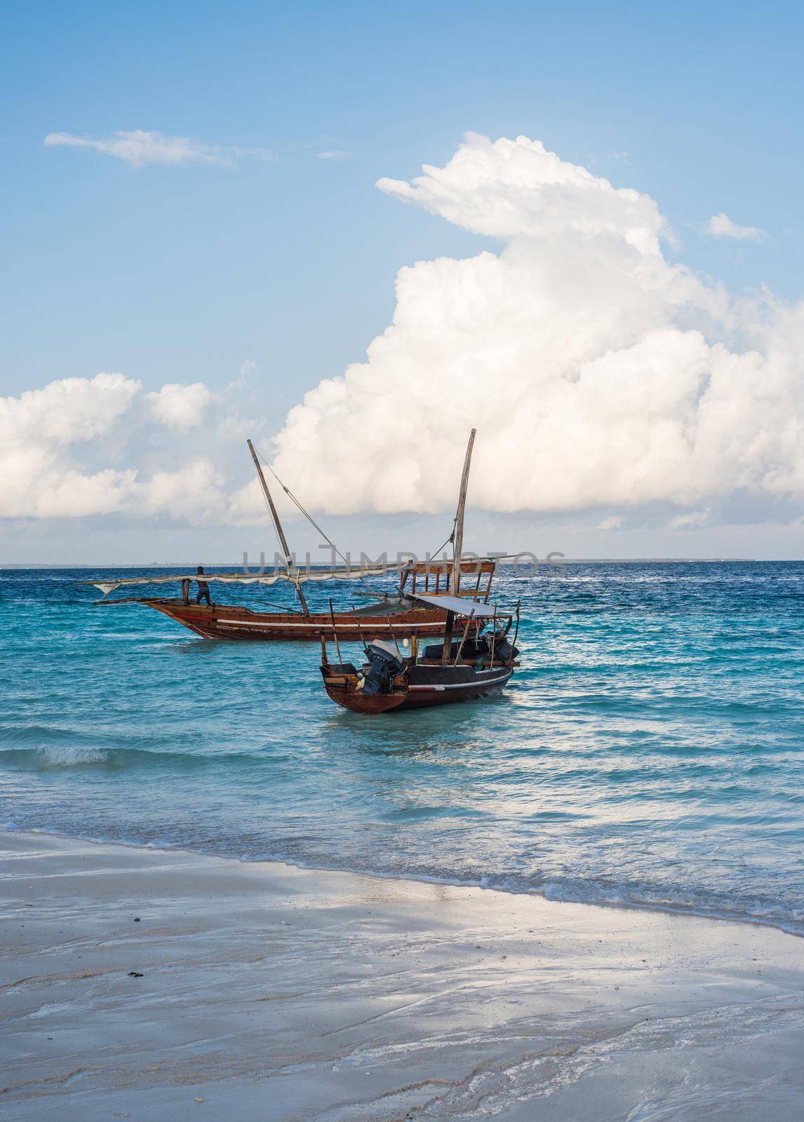two african boats near the shore with beautiful colorful sea and sky on the background
