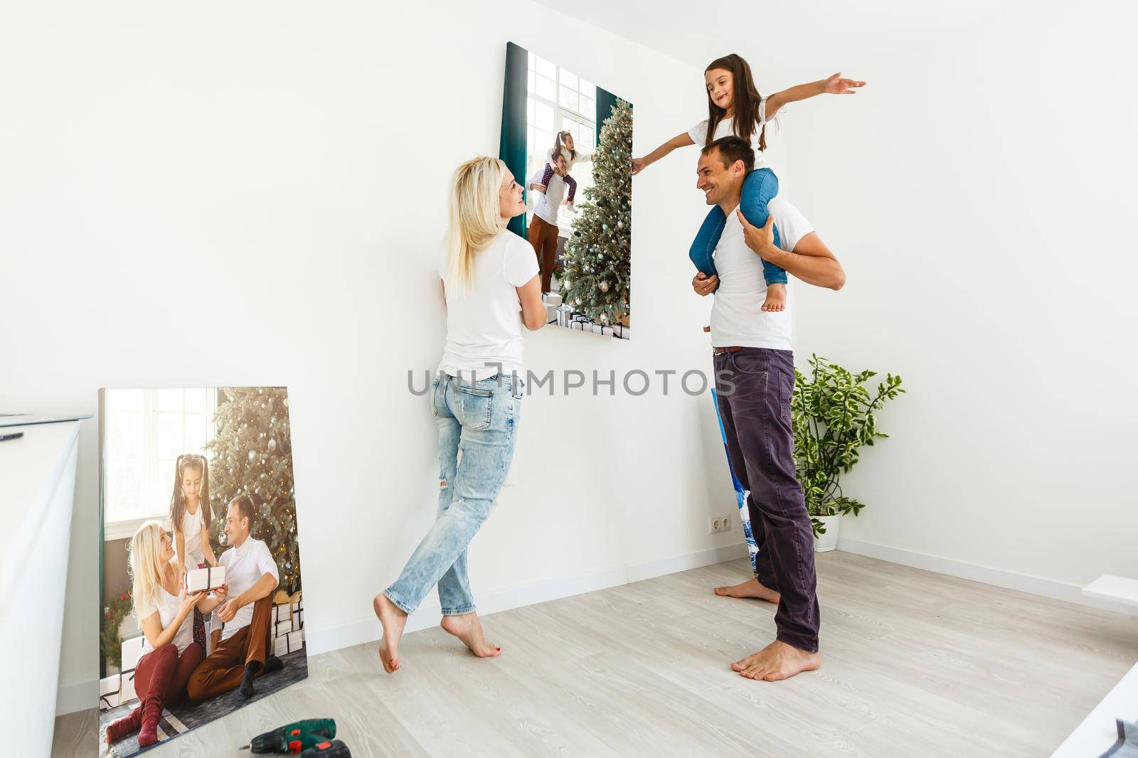 Smiling family holding photo canvas by Andelov13