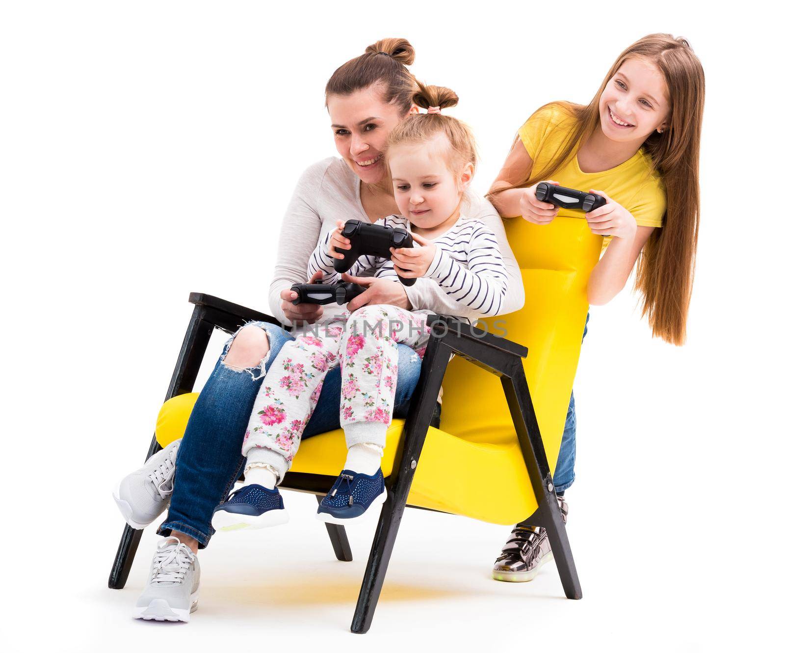 Family of three on leather yellow chair enjoying their time playing computer games with joystick