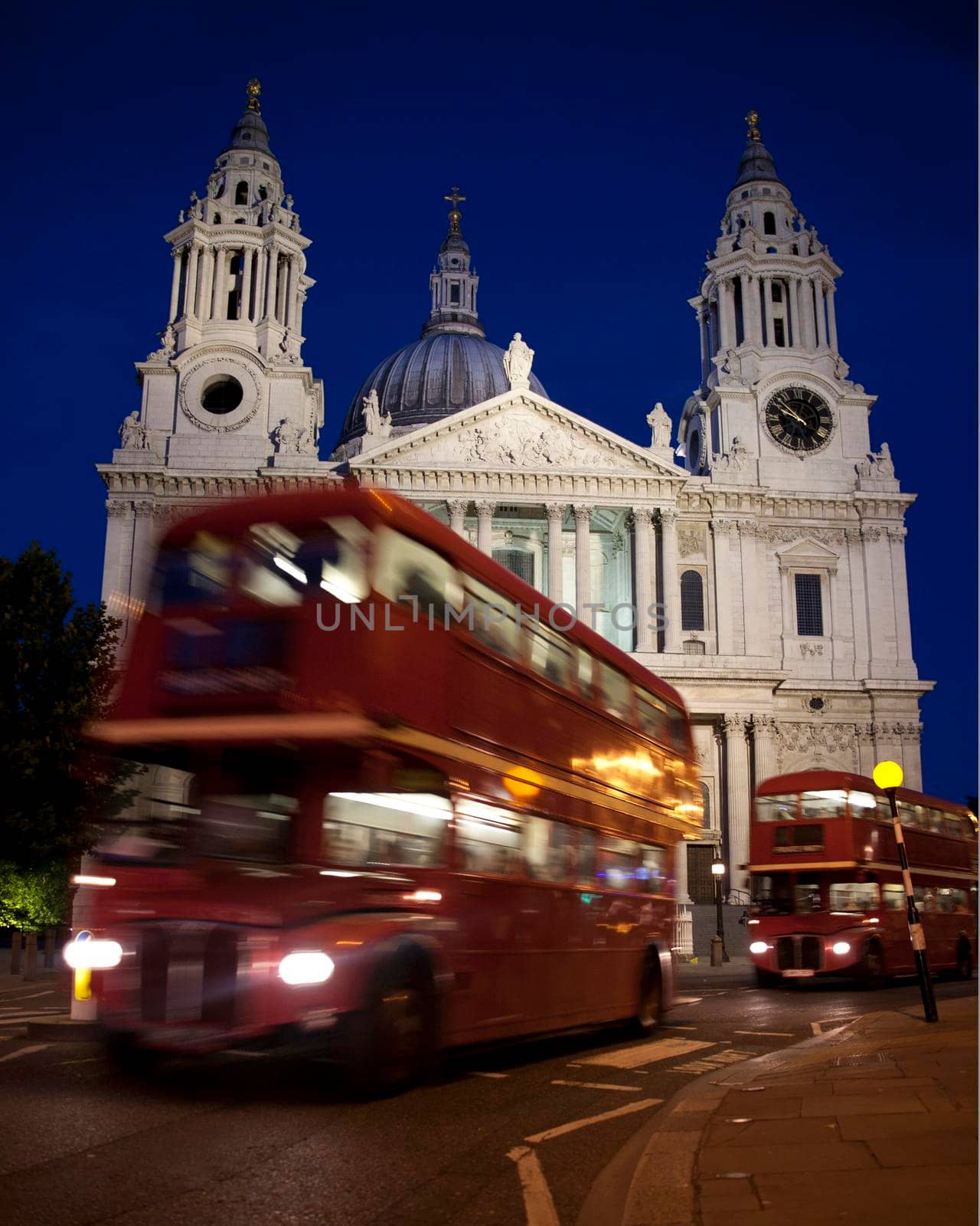 A red London Routemaster bus moving past St Pauls Cathedral Transport Movement London