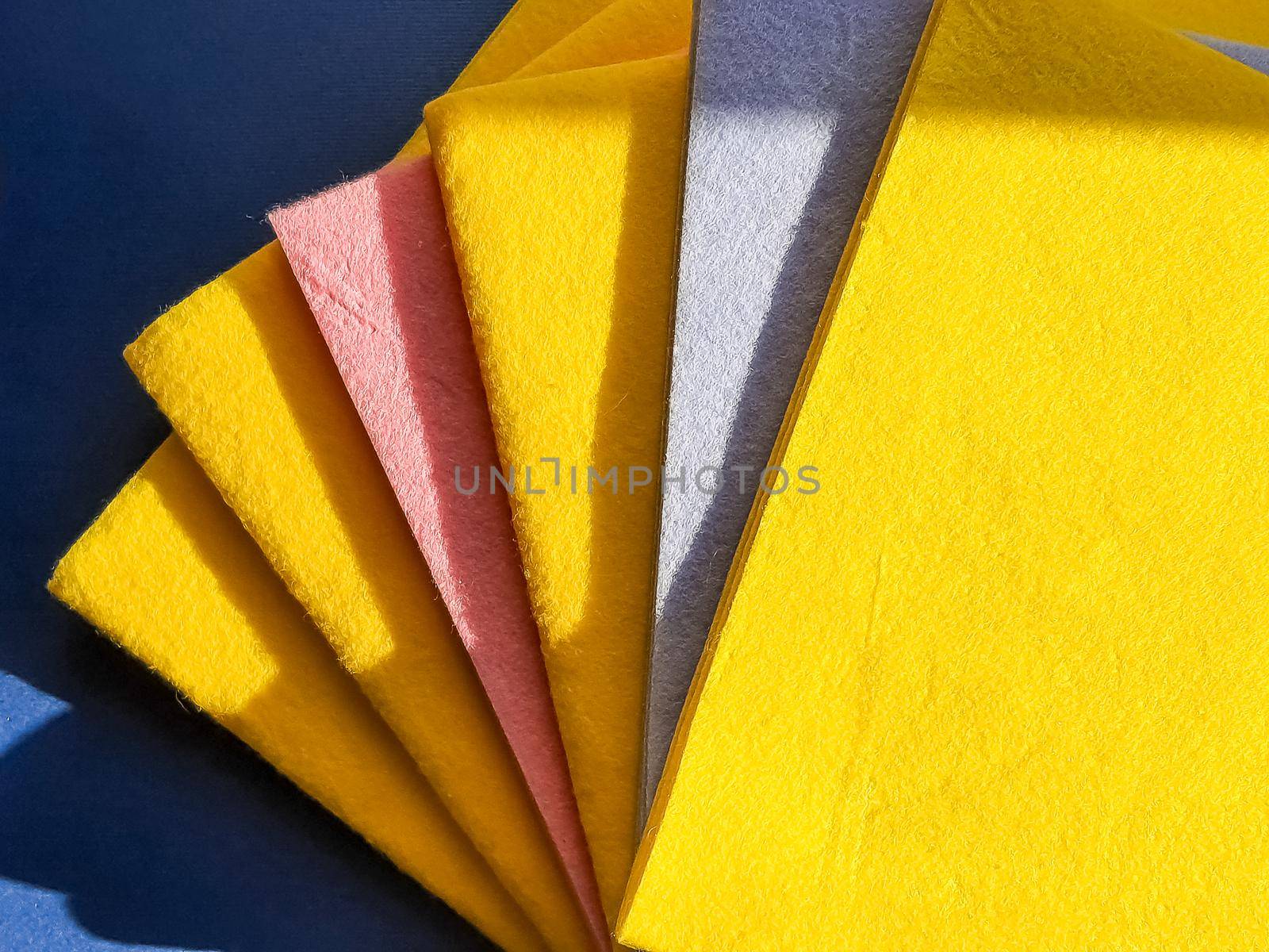 Colorful, dry microfiber cloths for different surfaces cleaning in kitchen, bathroom and other rooms. Empty place for text or logo on blue background. Cleaning service concept. Regular clean up.