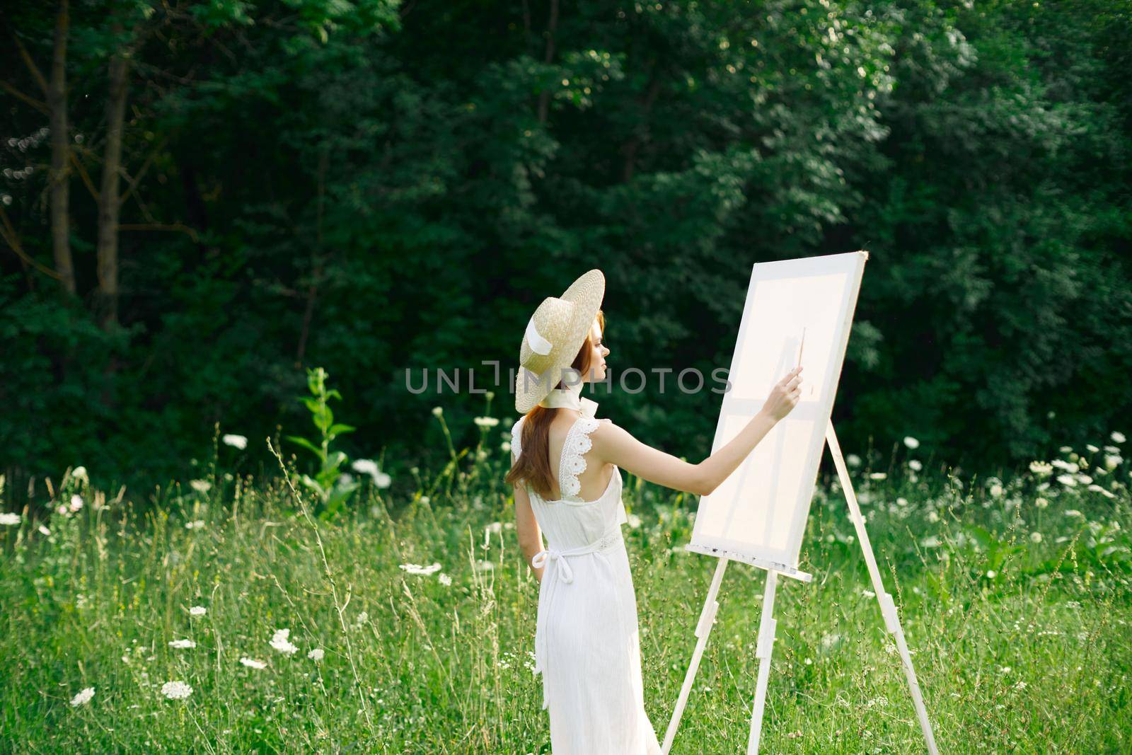 Woman in white dress in nature paints a picture of a landscape hobby by Vichizh