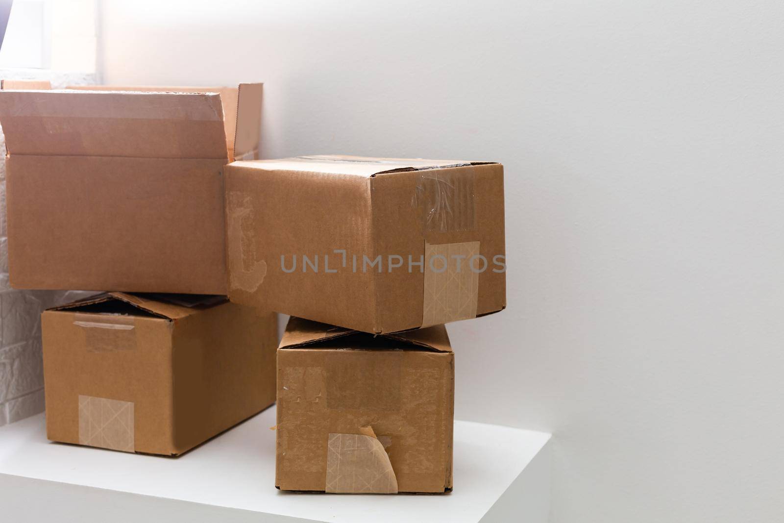 Moving in. Stack of cardboard boxes in the empty room with copy space by Andelov13