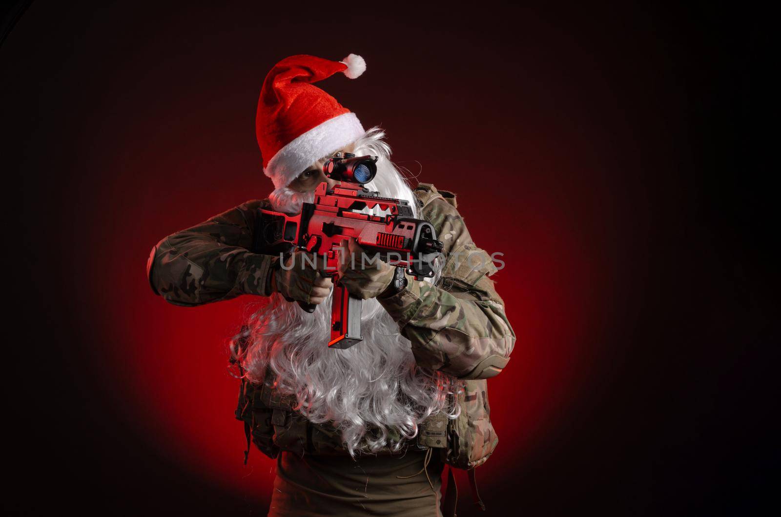 the man in a military uniform with a gun and a Santa Claus hat