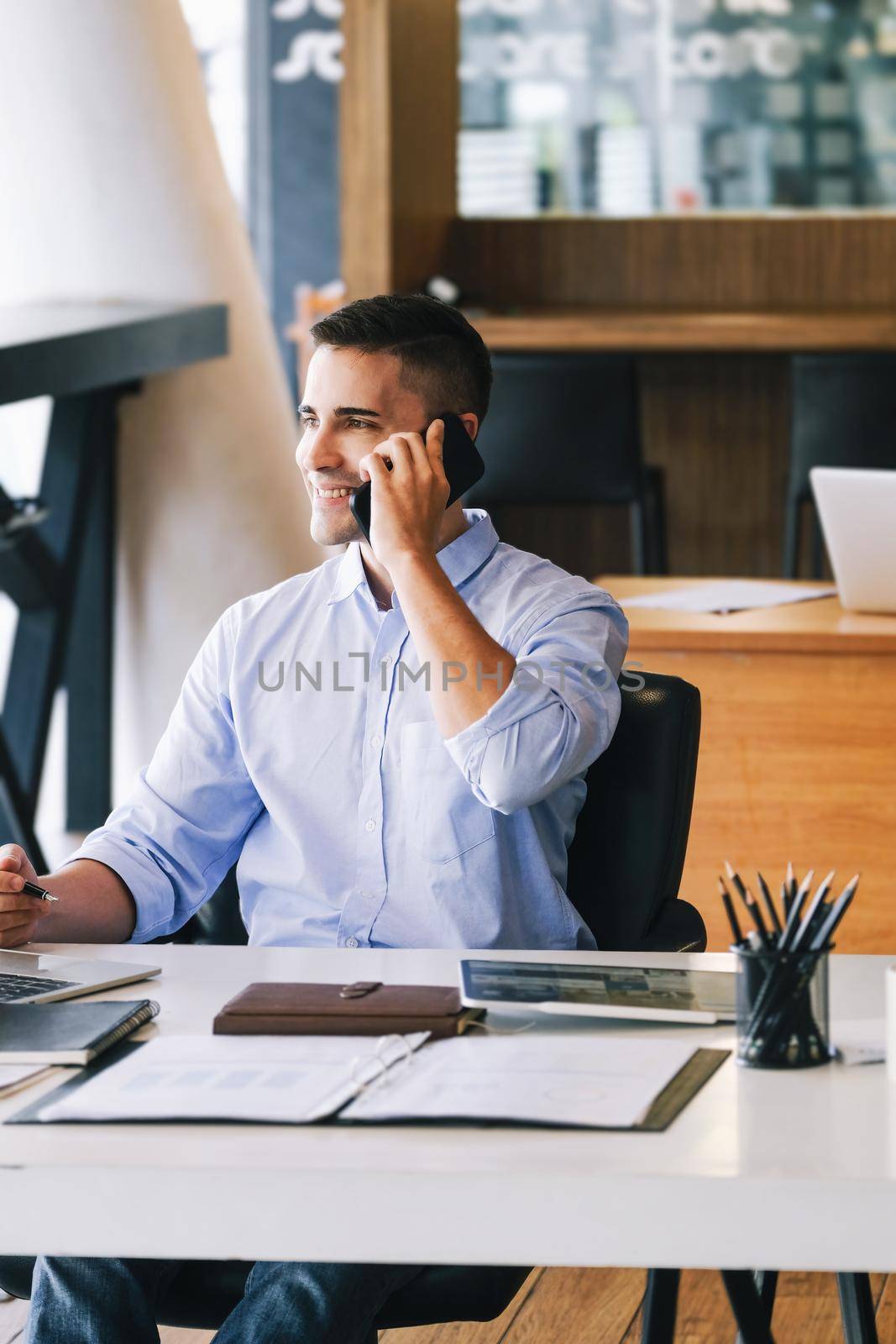 Male marketing manager using phone to talk to venture capital firm to increase profit potential. by Manastrong