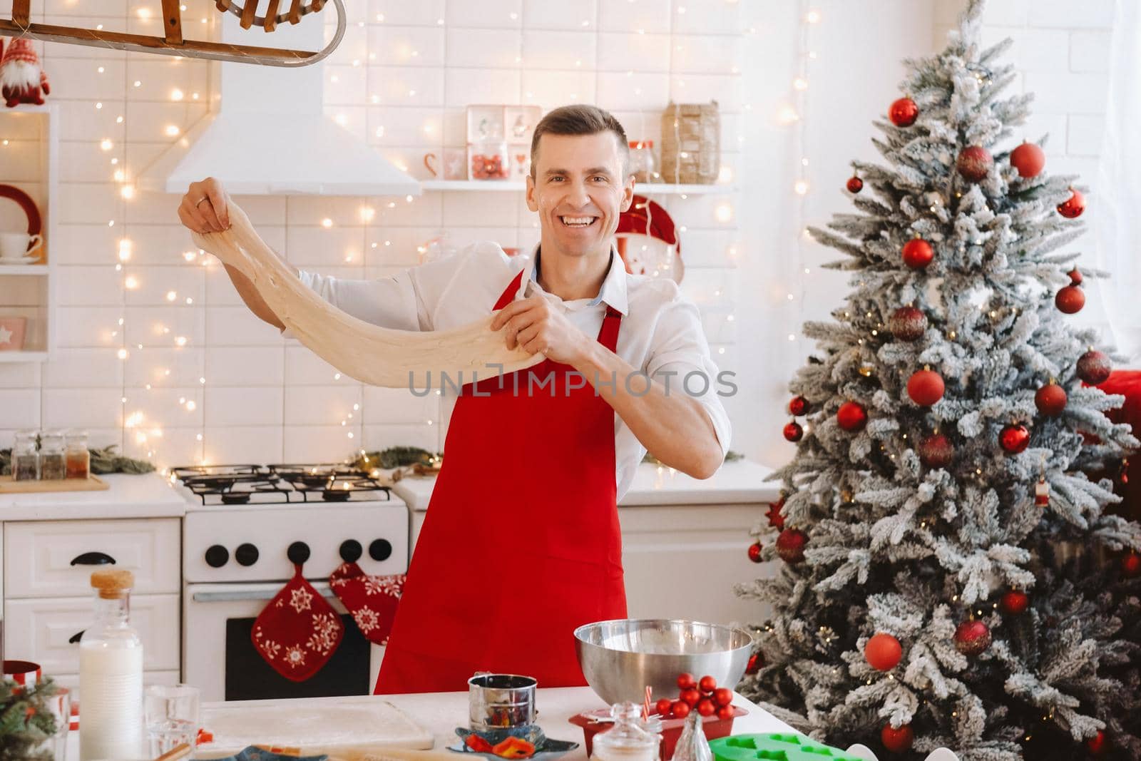 A male chef prepares dough in the Christmas kitchen before the New year.