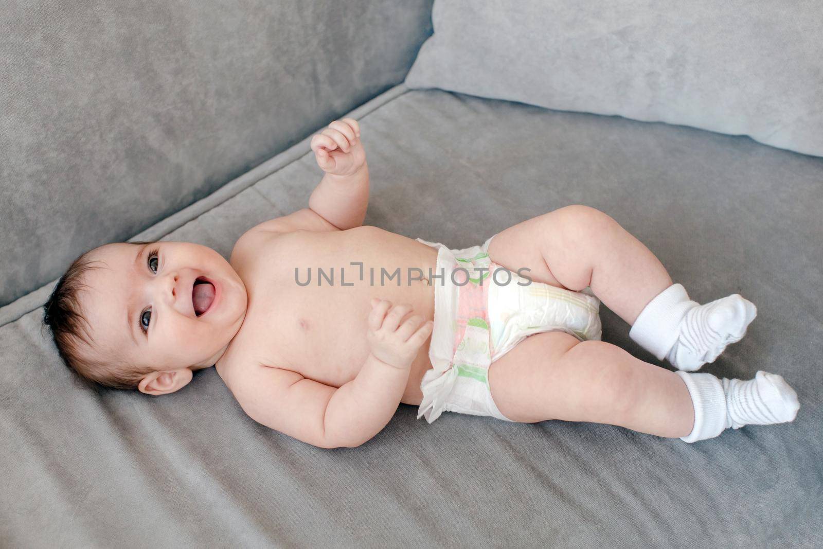 Cheerful adorable baby on sofa by Demkat