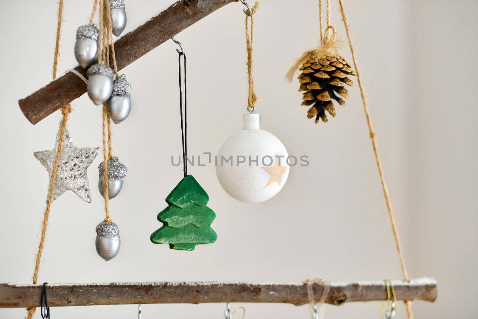 Handmade wooden Christmas tree with toys hanging on the wall