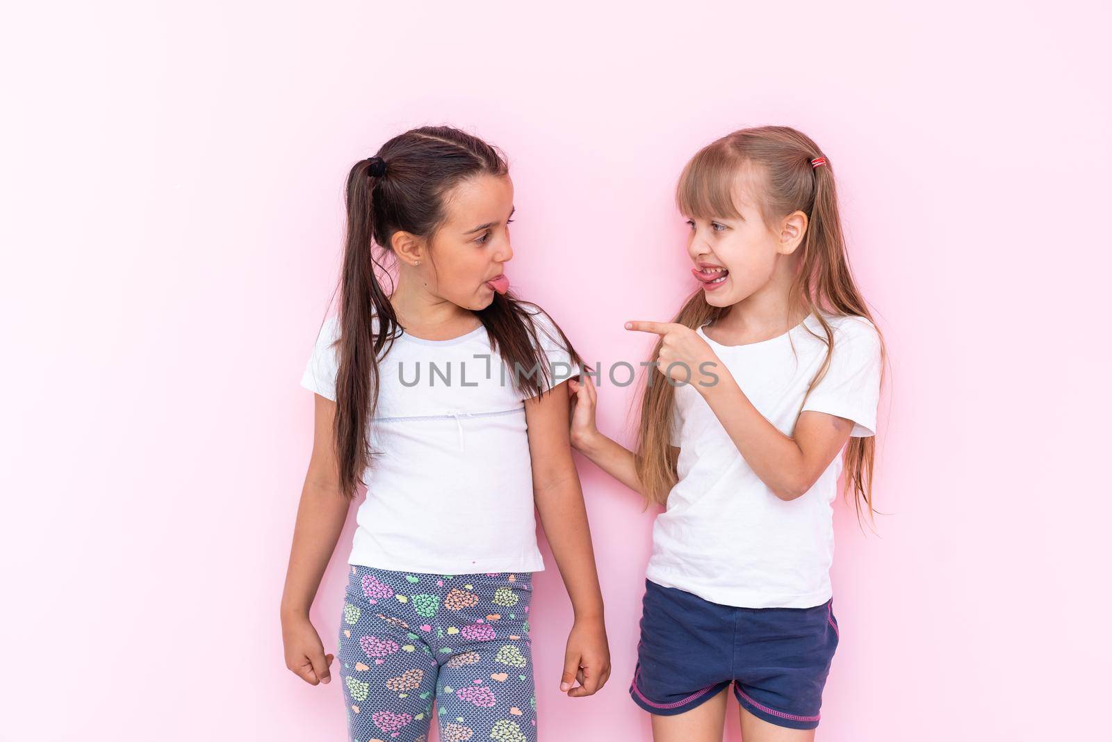 Two girls fighting over a pink background