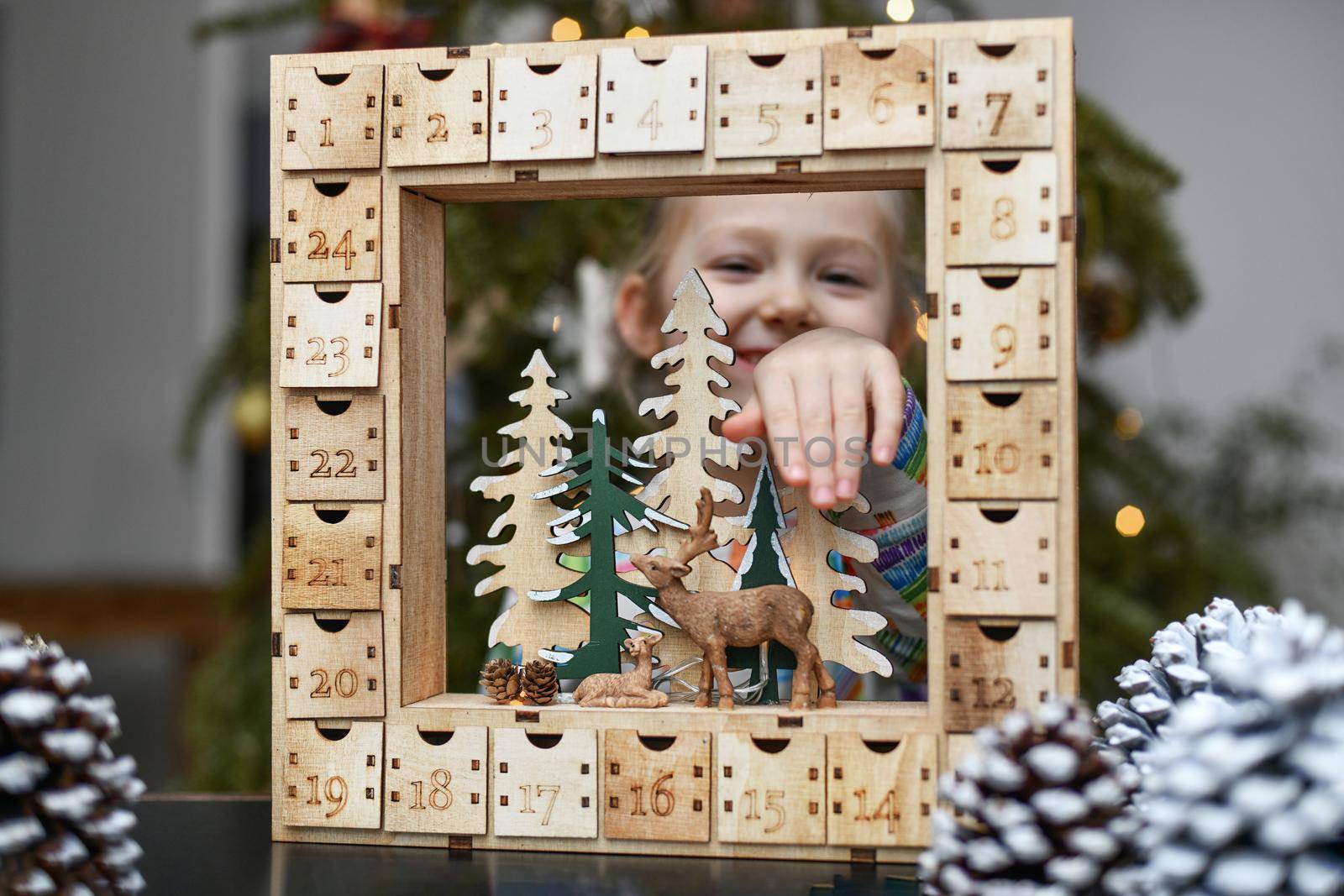 Girl opens wooden advent calendar