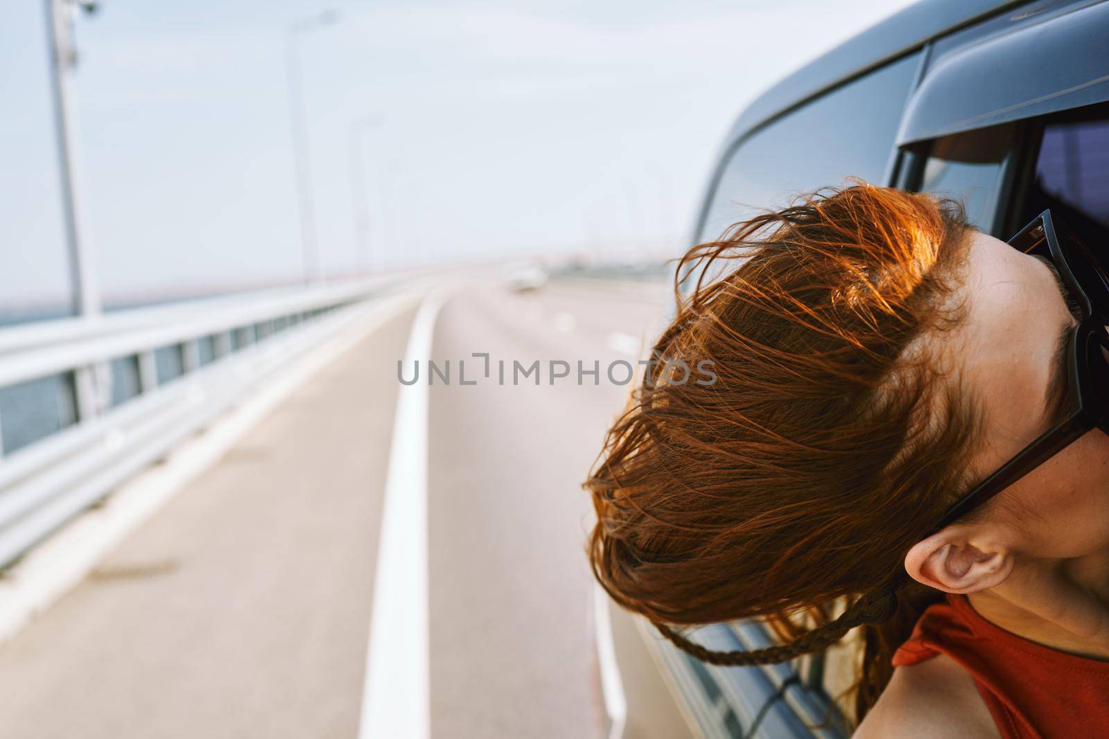 woman looking out of car window wearing sunglasses travel lifestyle by Vichizh