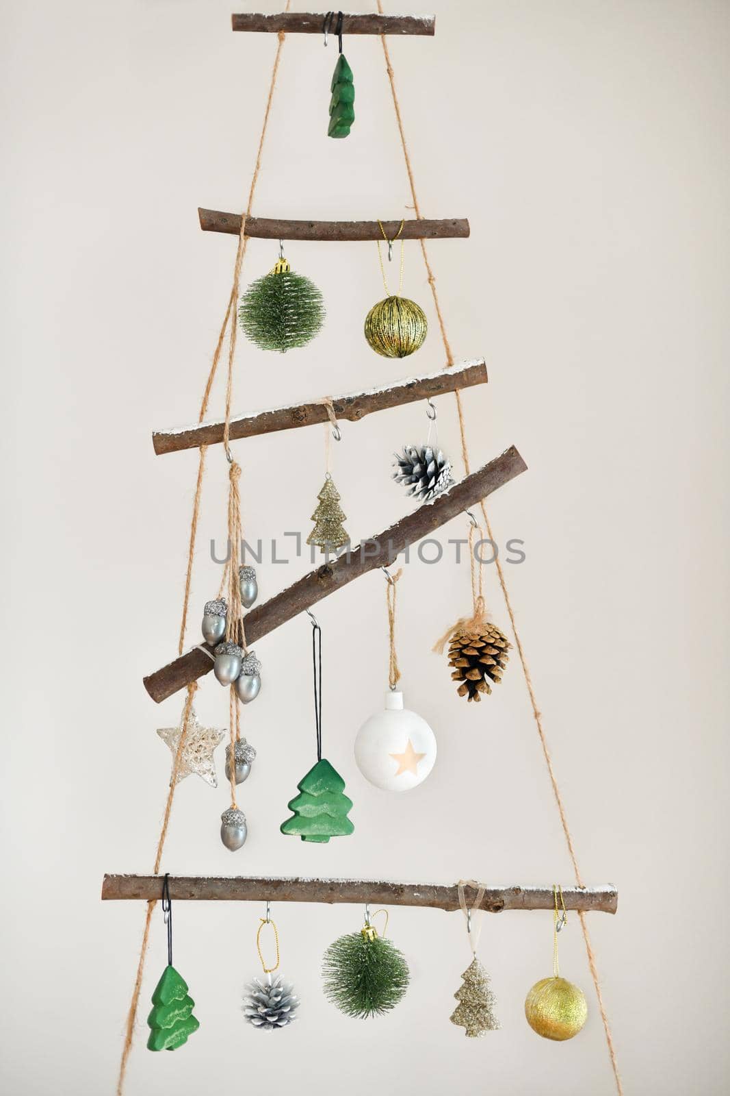 Handmade wooden Christmas tree with toys hanging on the wall