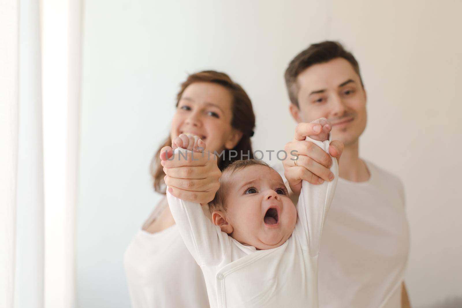Cheerful couple holding infant child by Demkat