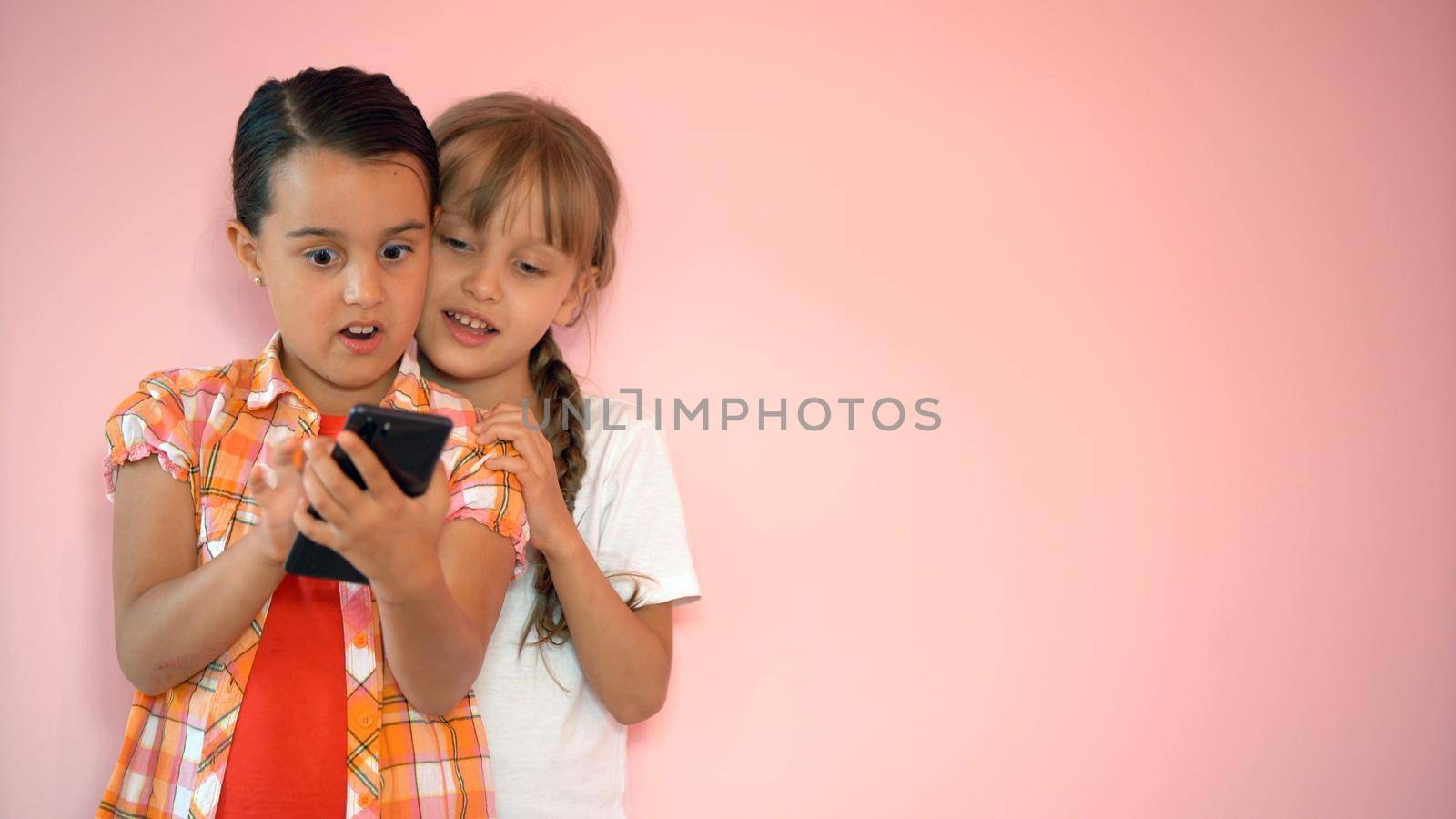 Happy little girls with a smartphone in hands communicate at home with loved ones using modern technology by Andelov13