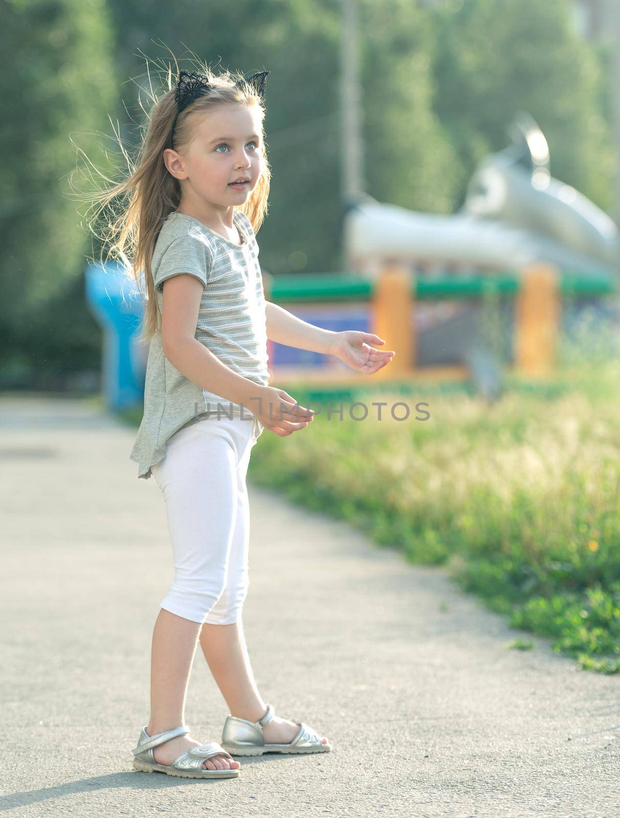 Little happy girl walking on the street
