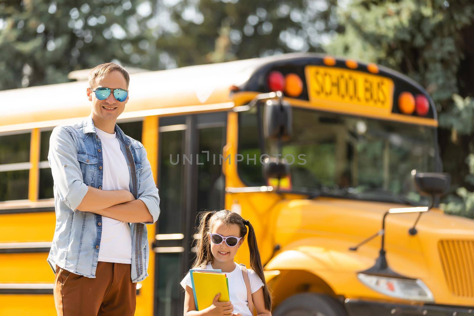 Girl with father going back to school near the school bus by Andelov13