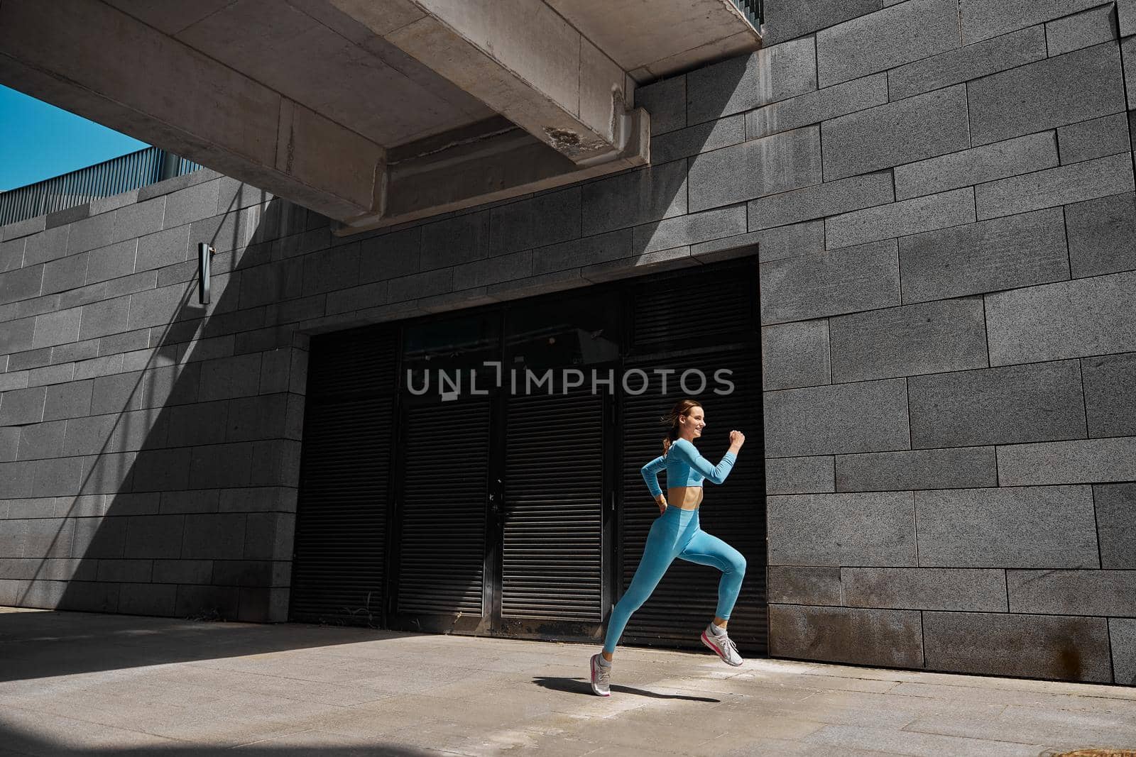 Beautiful fit young woman jogger is running outdoors by Yaroslav_astakhov