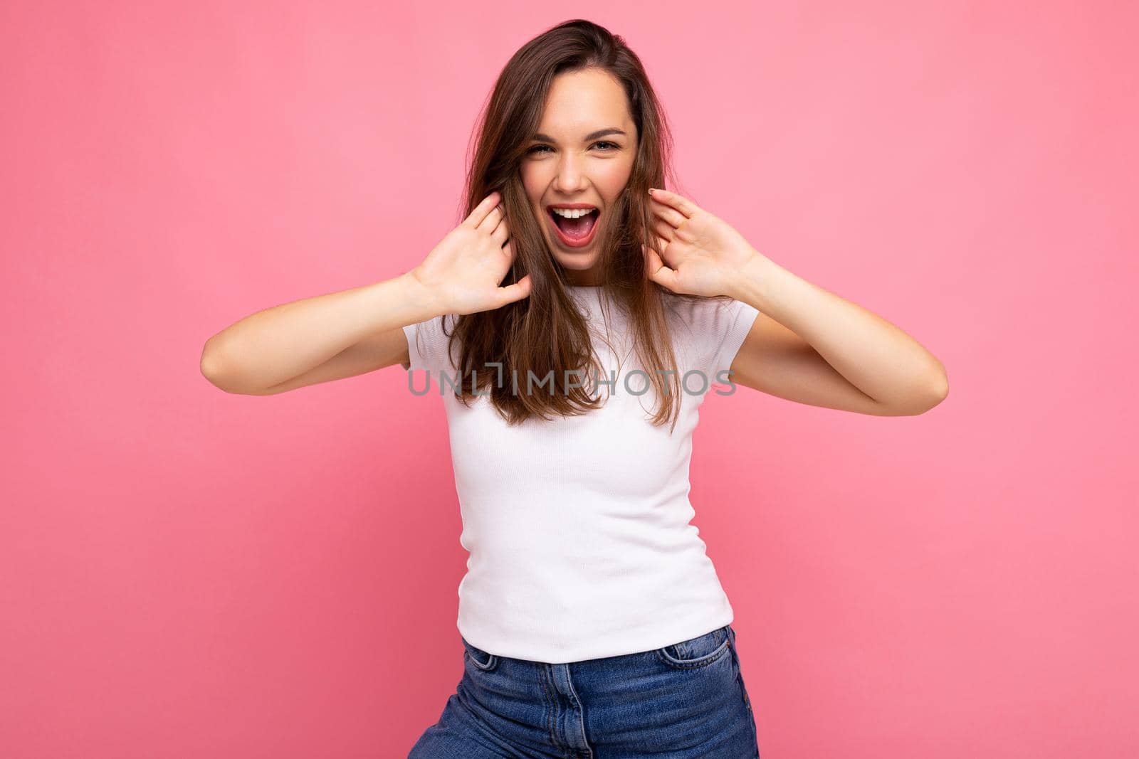 Portrait of positive cheerful fashionable woman in casual t-shirt for mock up isolated on pink background with copy space by TRMK