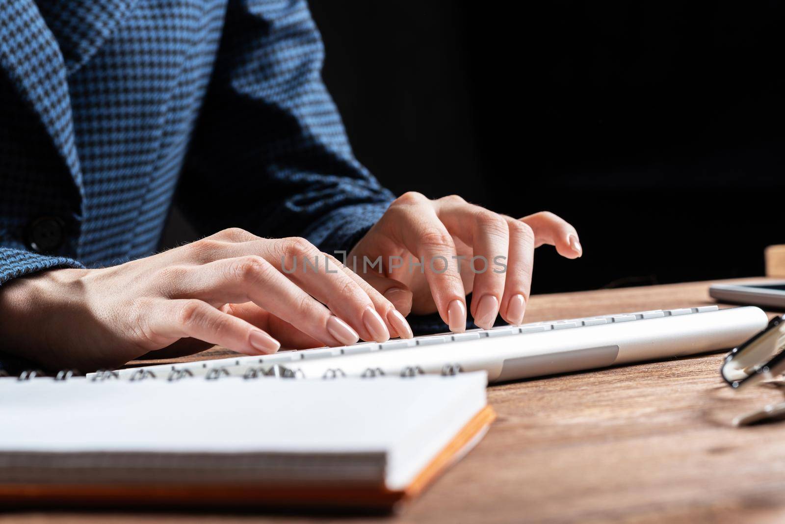Close up woman hands lying on laptop keyboard. Business lady working with computer at wooden desk. Financial specialist working at workplace in office. Business accounting and project management.