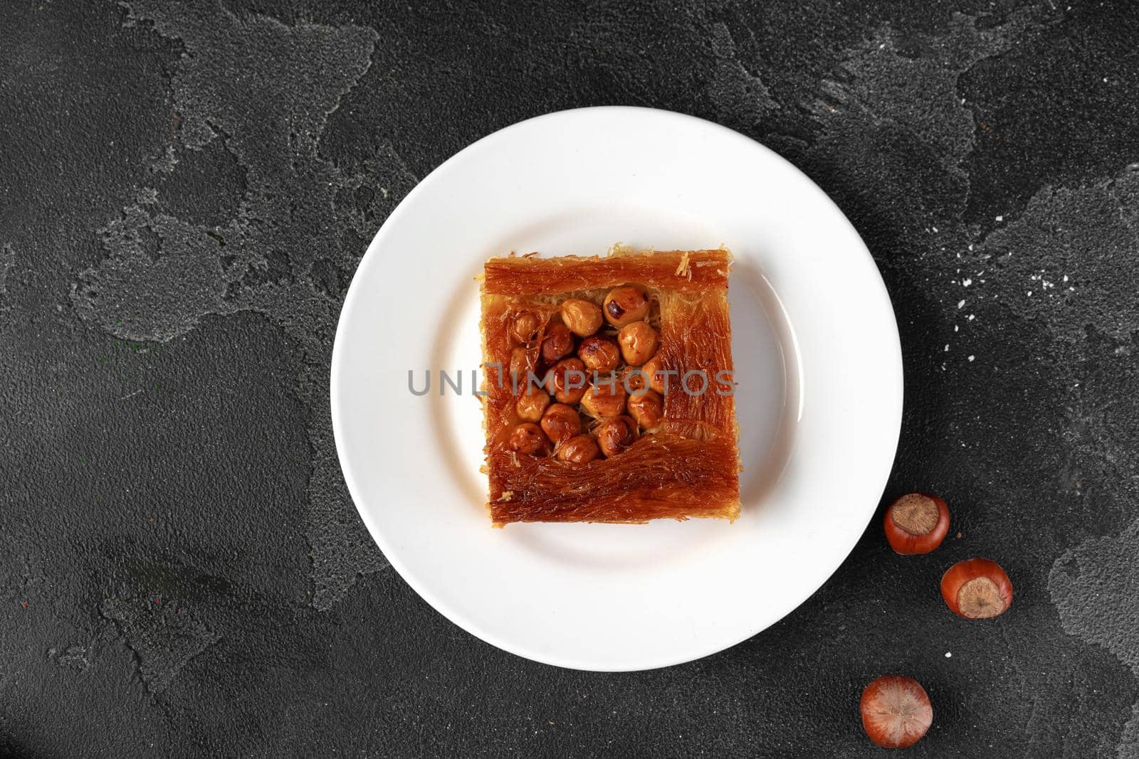 Turkish dessert baklava with nuts on black background, close up