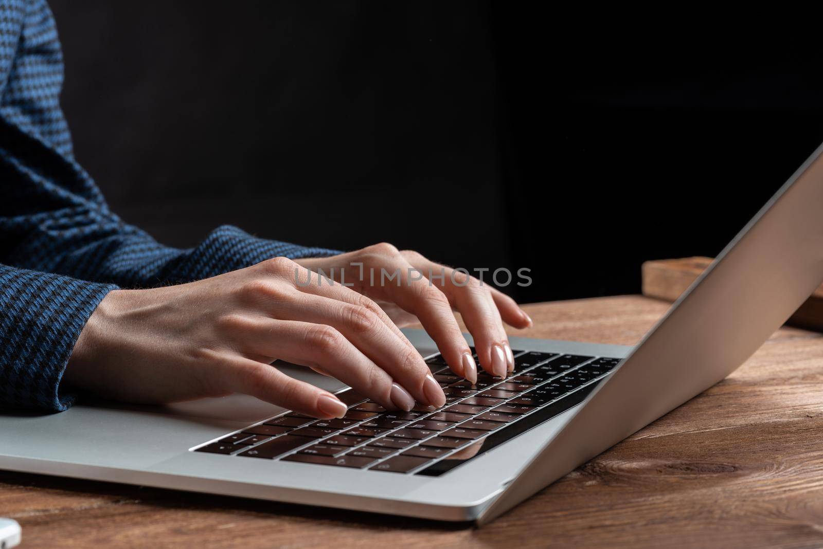 Close up woman hands lying on laptop keyboard. Business lady working with computer at wooden desk. Financial specialist working at workplace in office. Business accounting and project management.