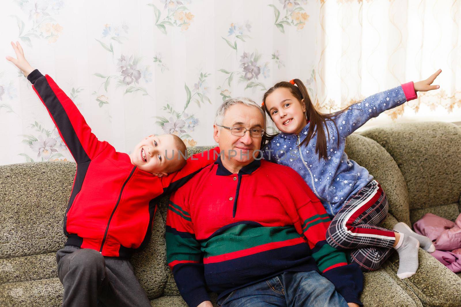 grandfather spends time with grandchildren in the living room by Andelov13