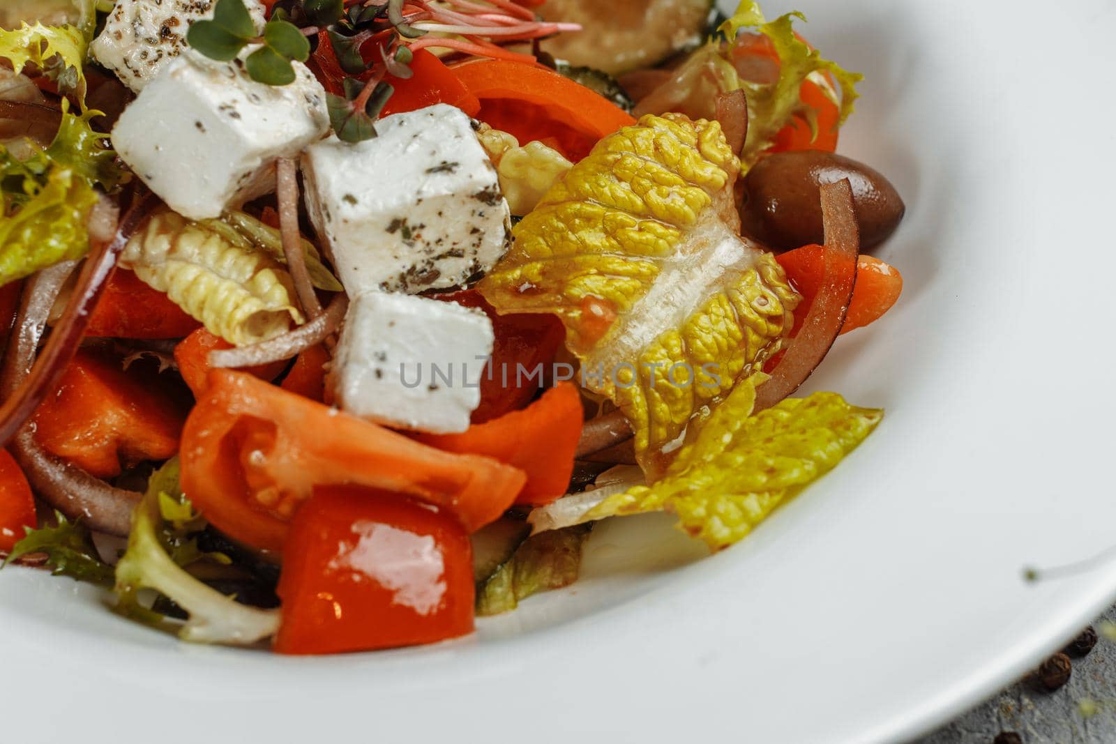 Greek salad with fresh vegetables, feta cheese and black olives.