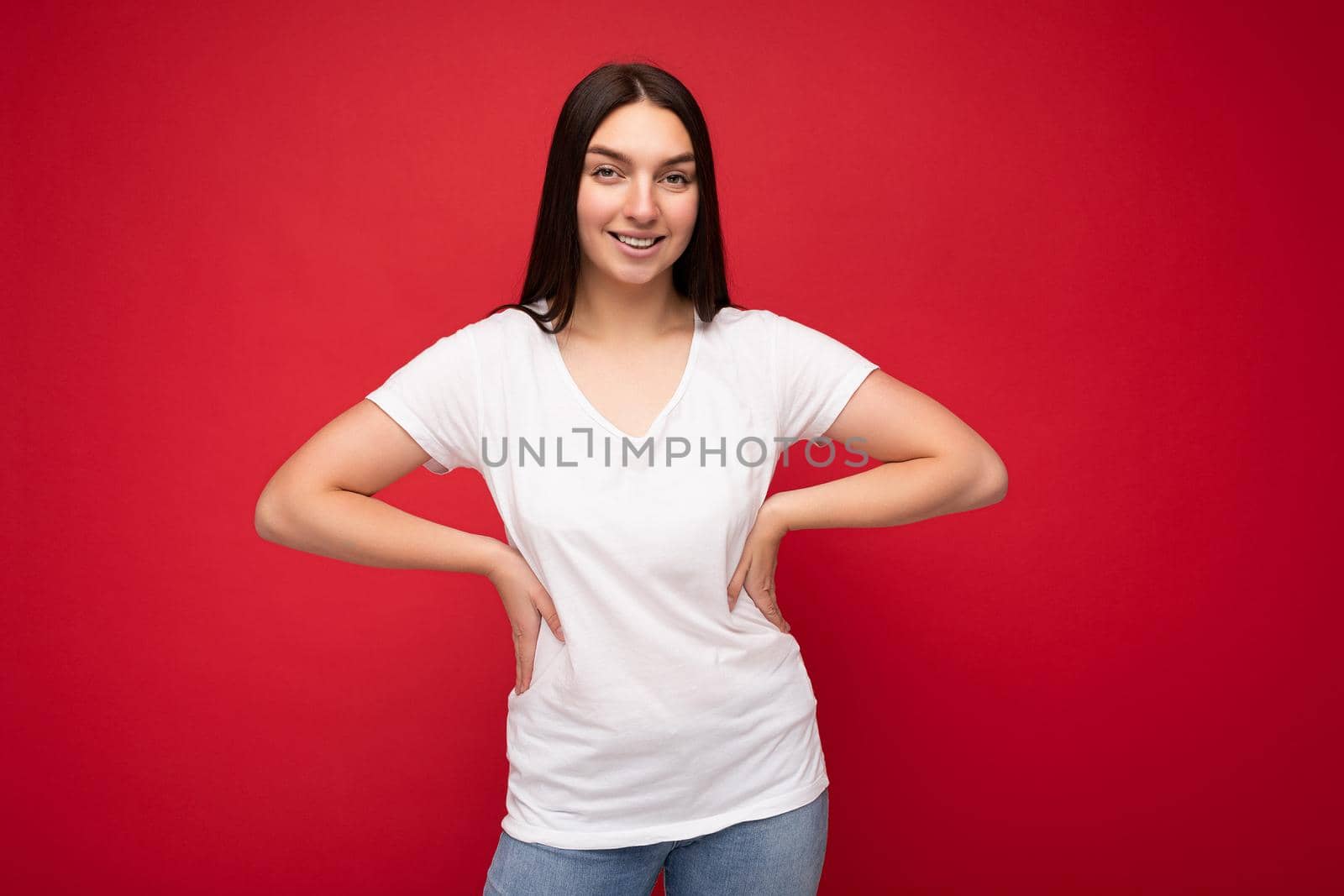 Young smiling pretty brunette woman with sincere emotions isolated on background wall with copy space wearing casual white t-shirt for mockup. Happy concept by TRMK