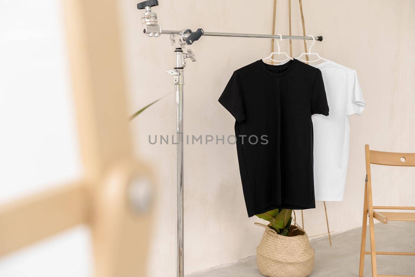 White and black T-shirts on hangers for design presentation, copy space